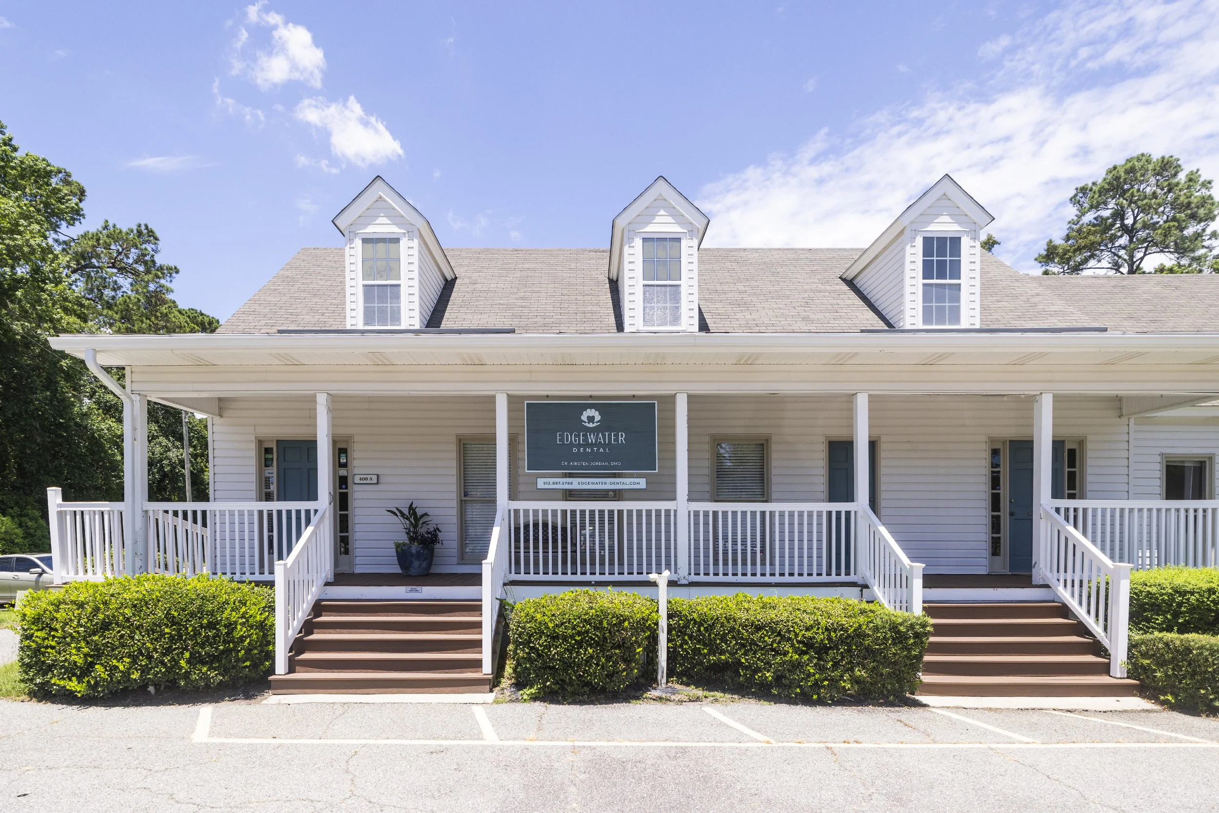 Exterior of the Edgewater Dental office building with a porch, stairs, and signage.