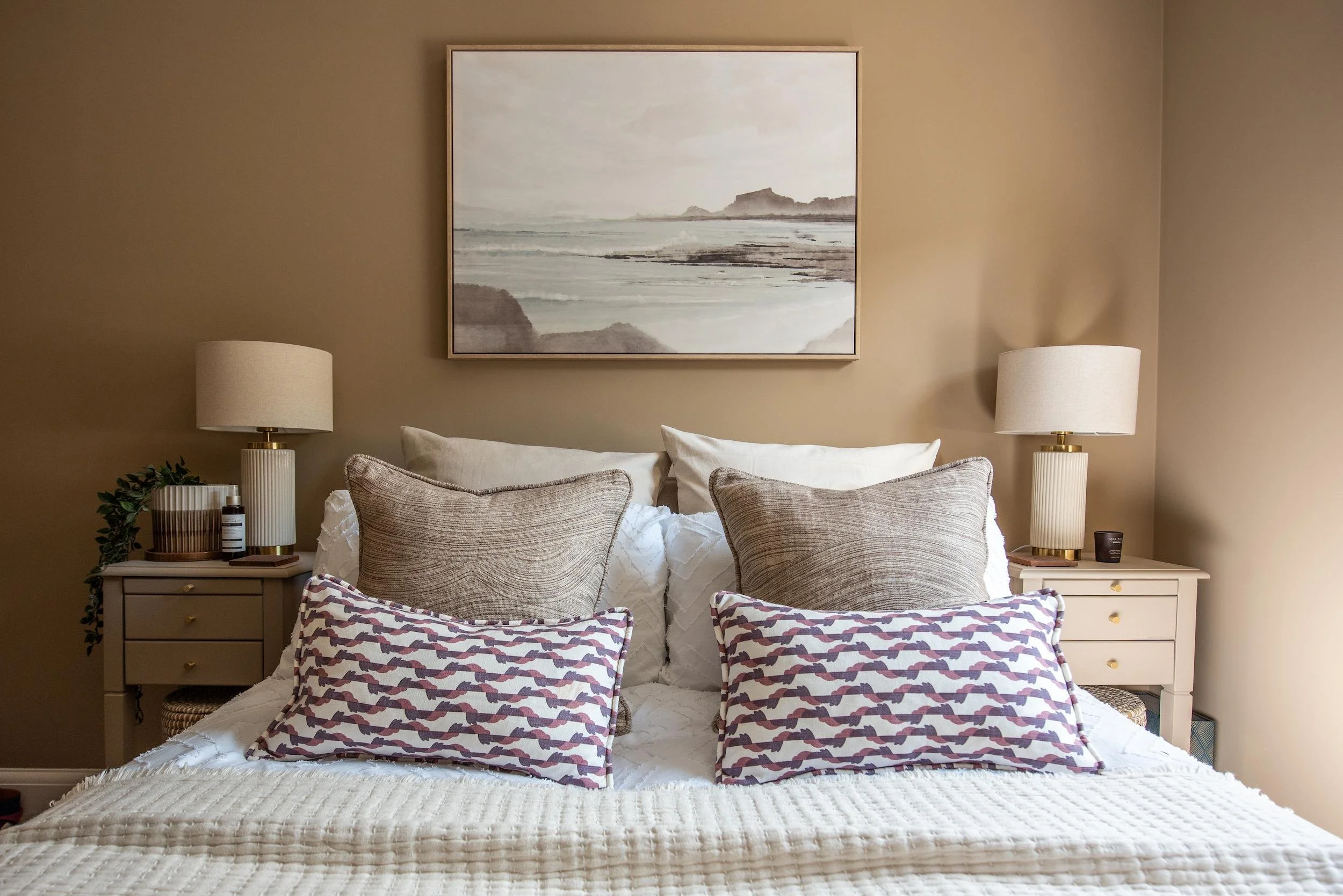 Inviting Bed layered with subtly patterned textiles.