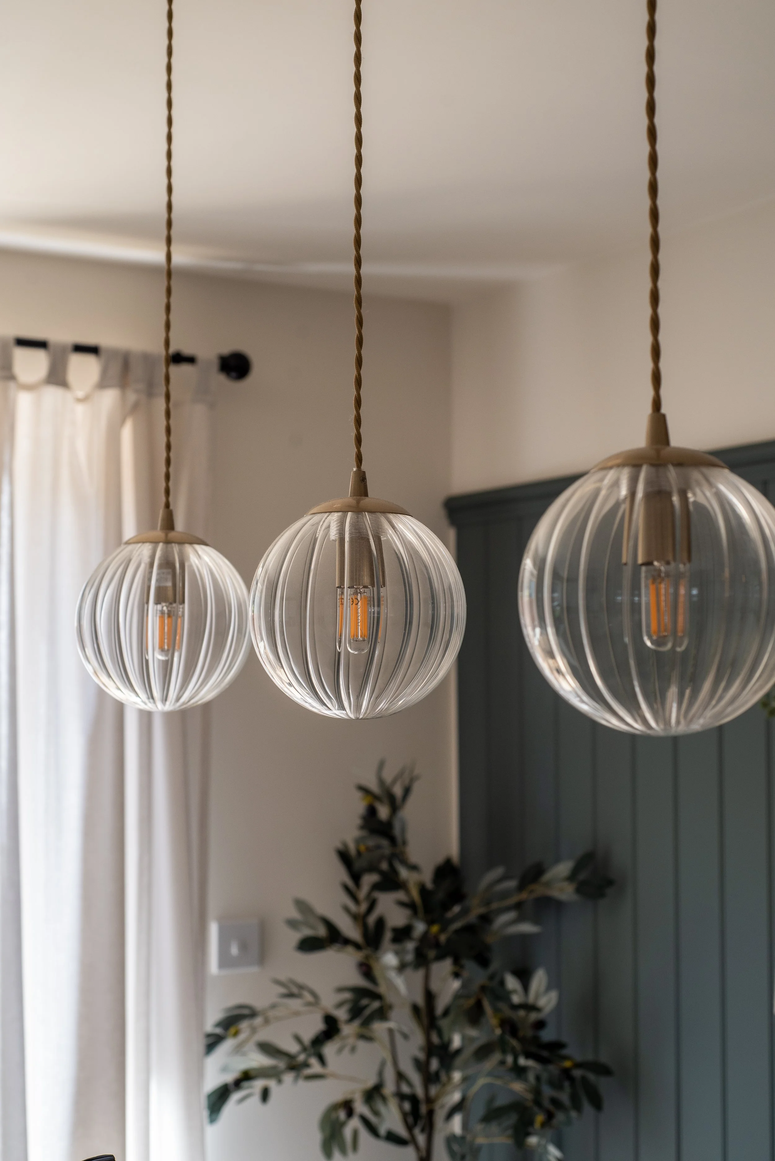 Fluted Glass pendant lights hung over dining table in Devon New Build Kitchen