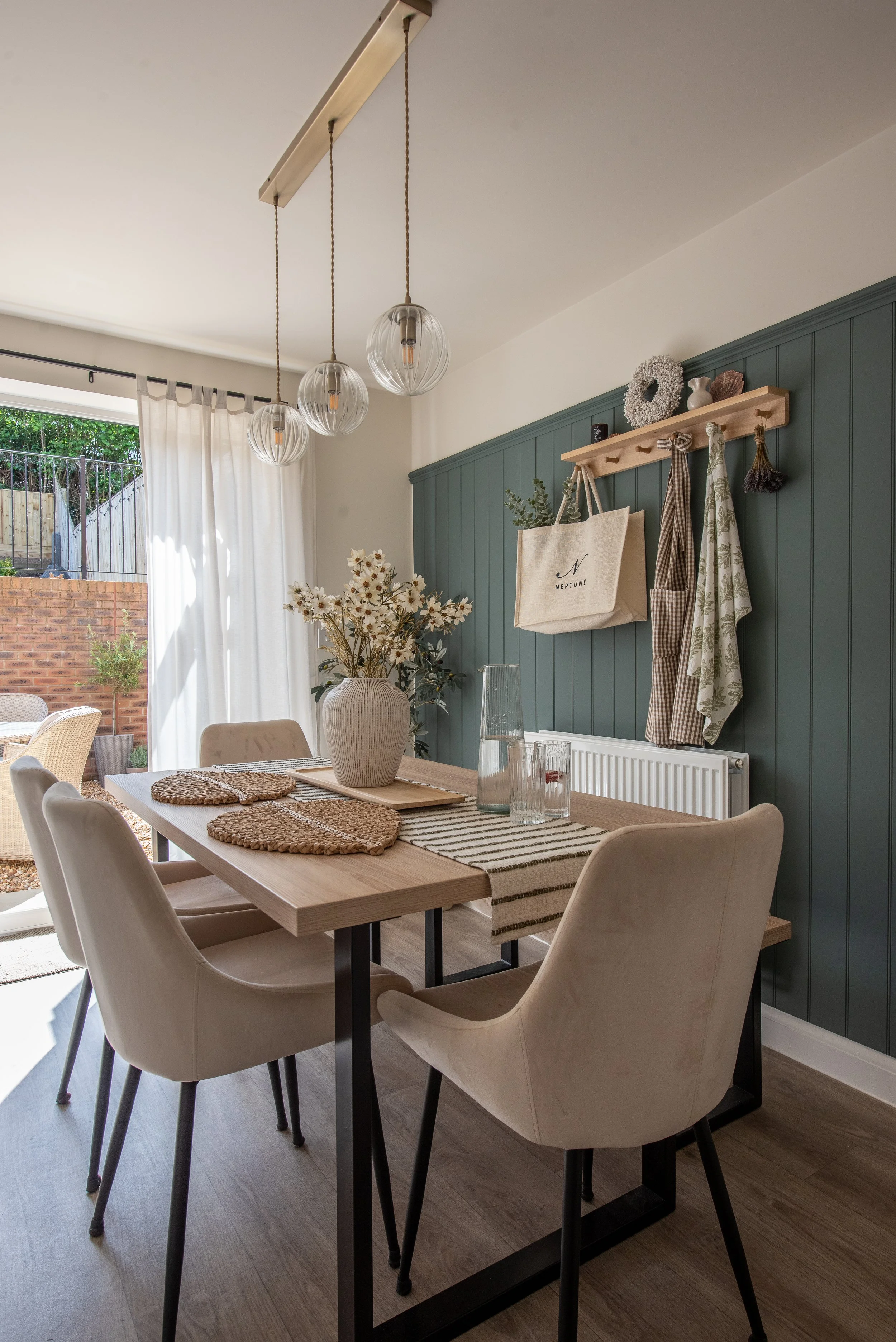 Modern Country Dining Area in a New Build on Dartmoor, featuring velvet dining chairs, ribbed glass pendant lights, voile curtains and tongue and groove panelling