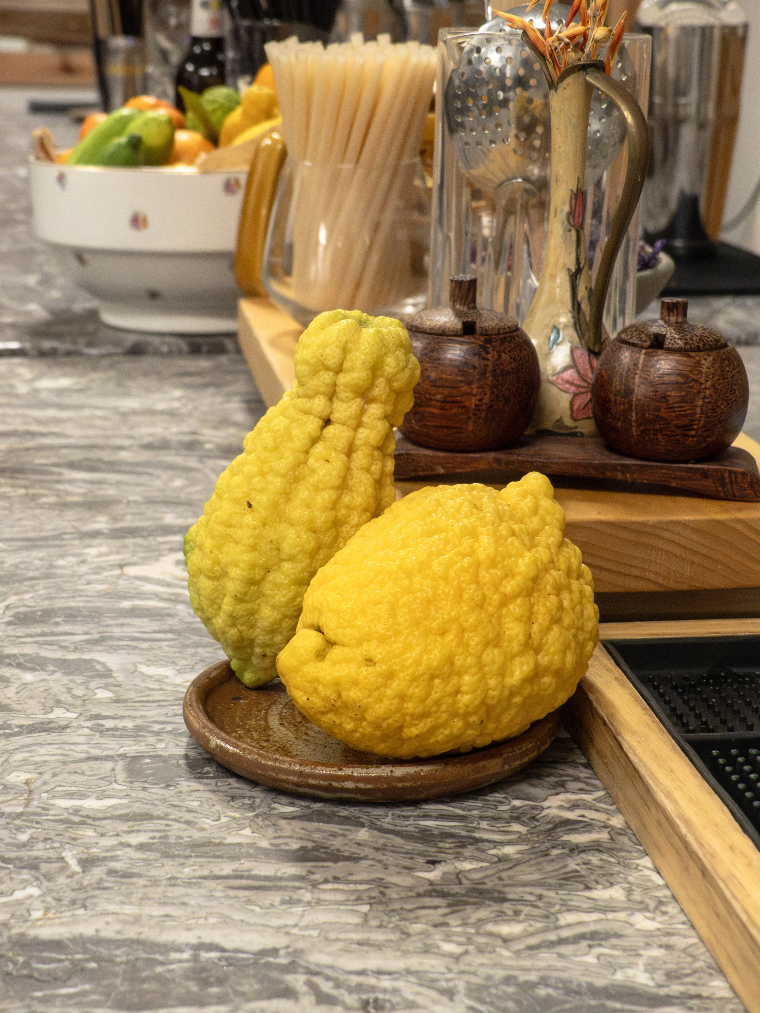 Sunset Spirit 2025, Deux cédrats jaunes sur une assiette en céramique sur un comptoir de cuisine