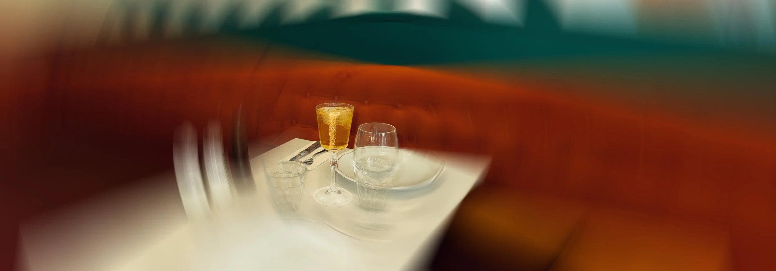 Verre de champagne, verre d'eau, et verre d'eau avec une assiette à proximité sur une table dans un restaurant