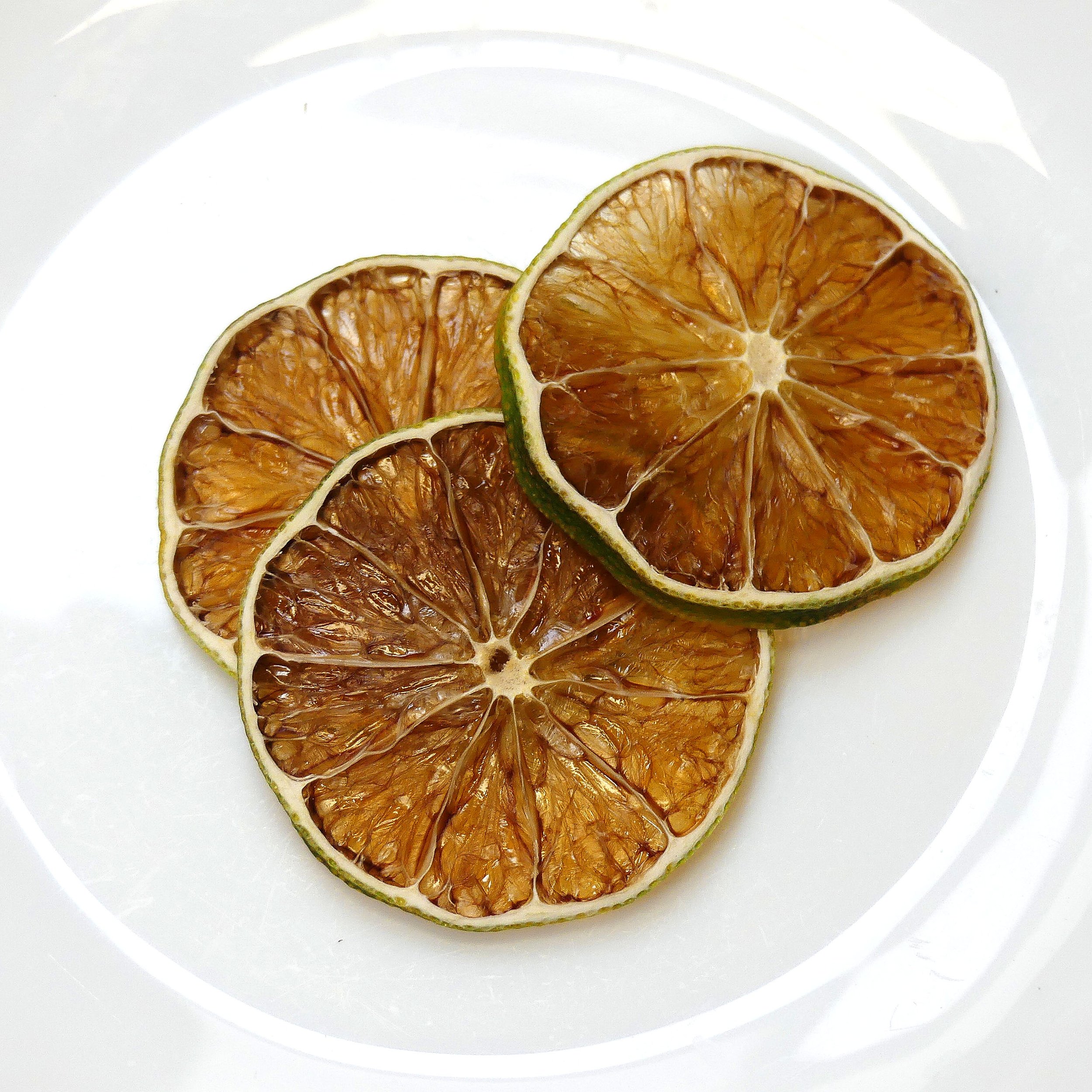 Tranches de citron séchées sur une assiette blanche.