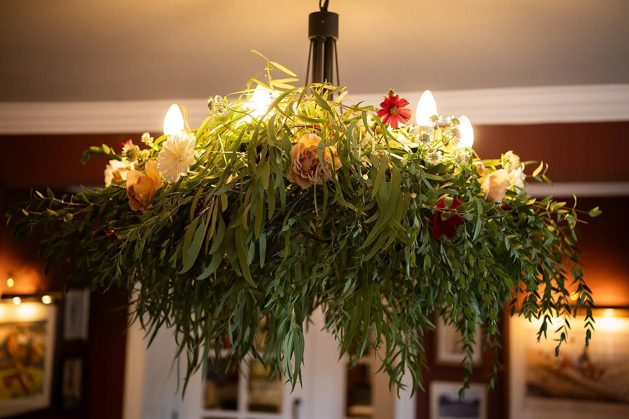 Chandelier installation eucalyptus and seasonal flowers 