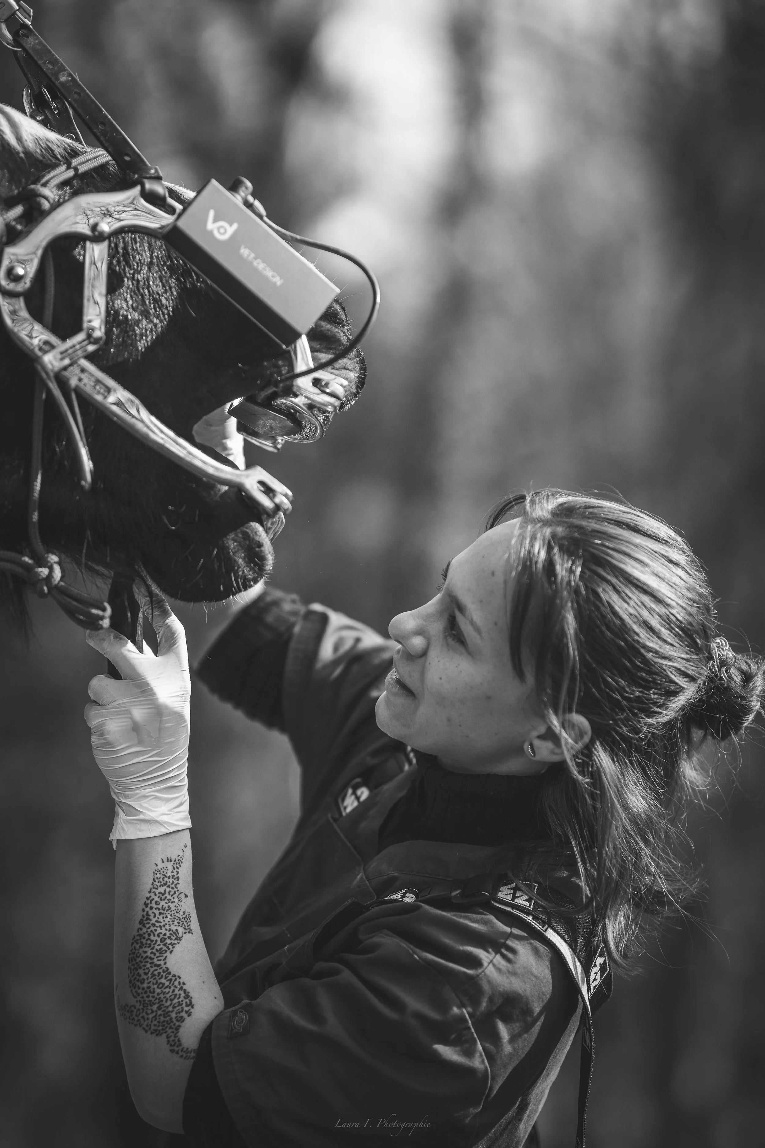 Une femme regarde un chien avec un masque de réalité virtuelle, en noir et blanc.