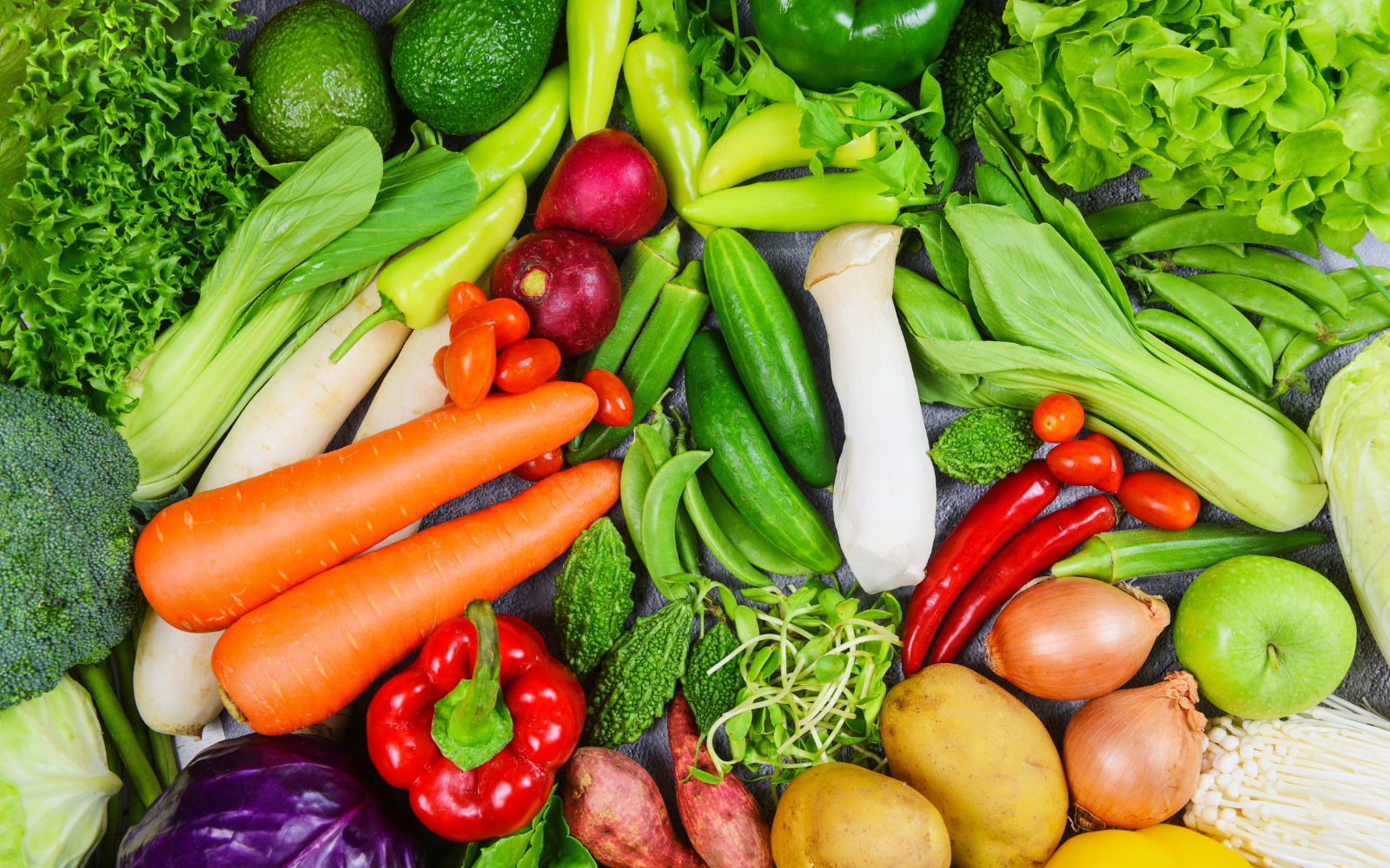 Fresh vegetables including carrots, bell peppers, potatoes, onions, tomatoes, cucumbers, lettuce, broccoli, and green beans.