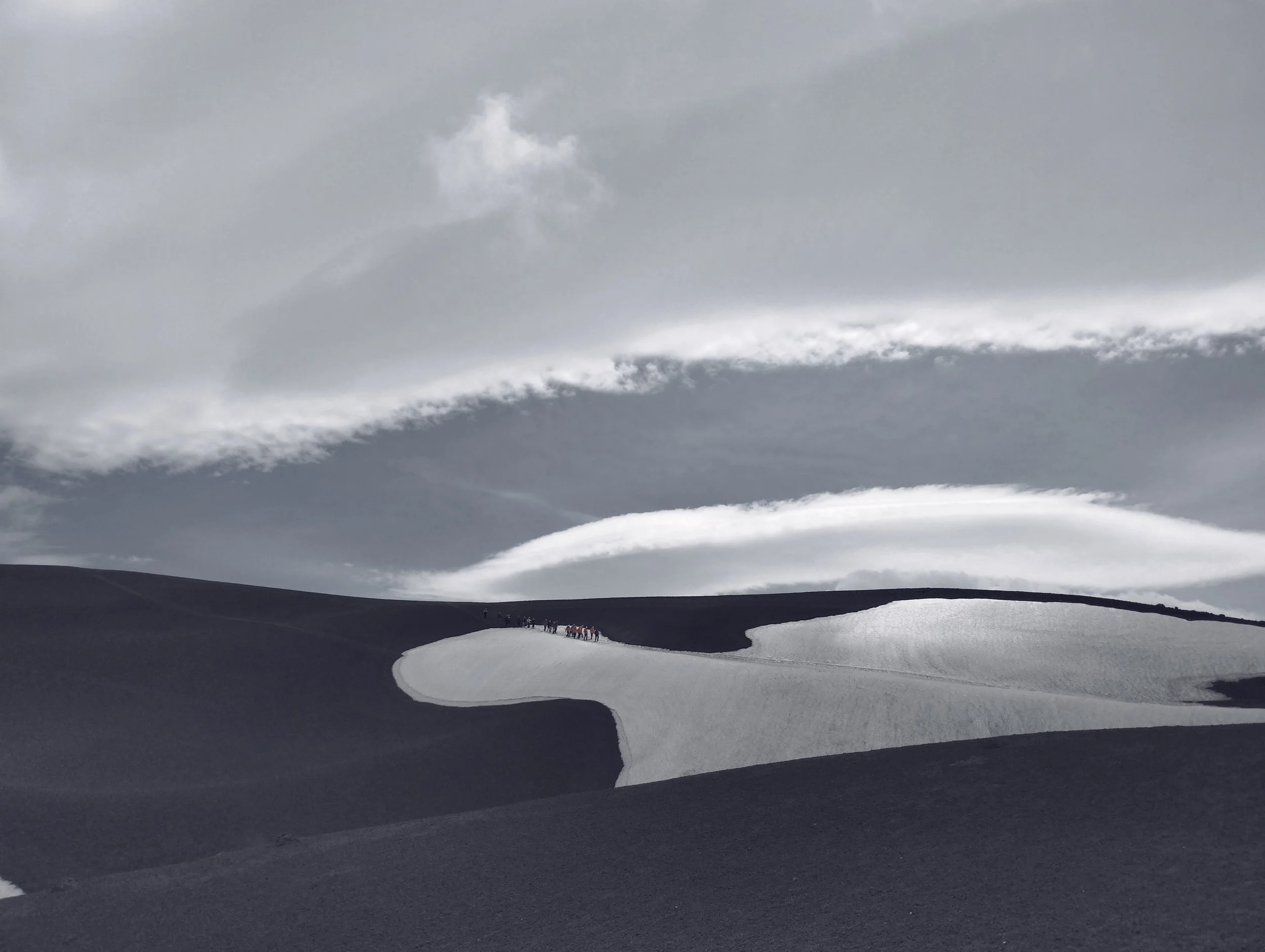 Abstract curve of snow against dark ground, black and white minimalist landscape.
