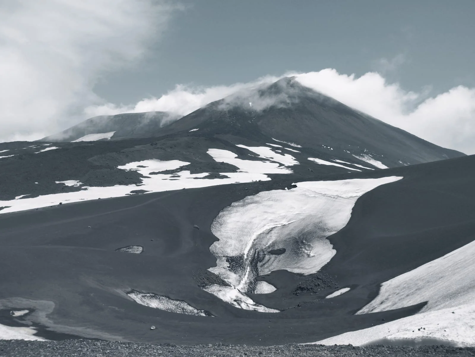 Minimalist snow-covered ridge under open sky, black and white landscape.