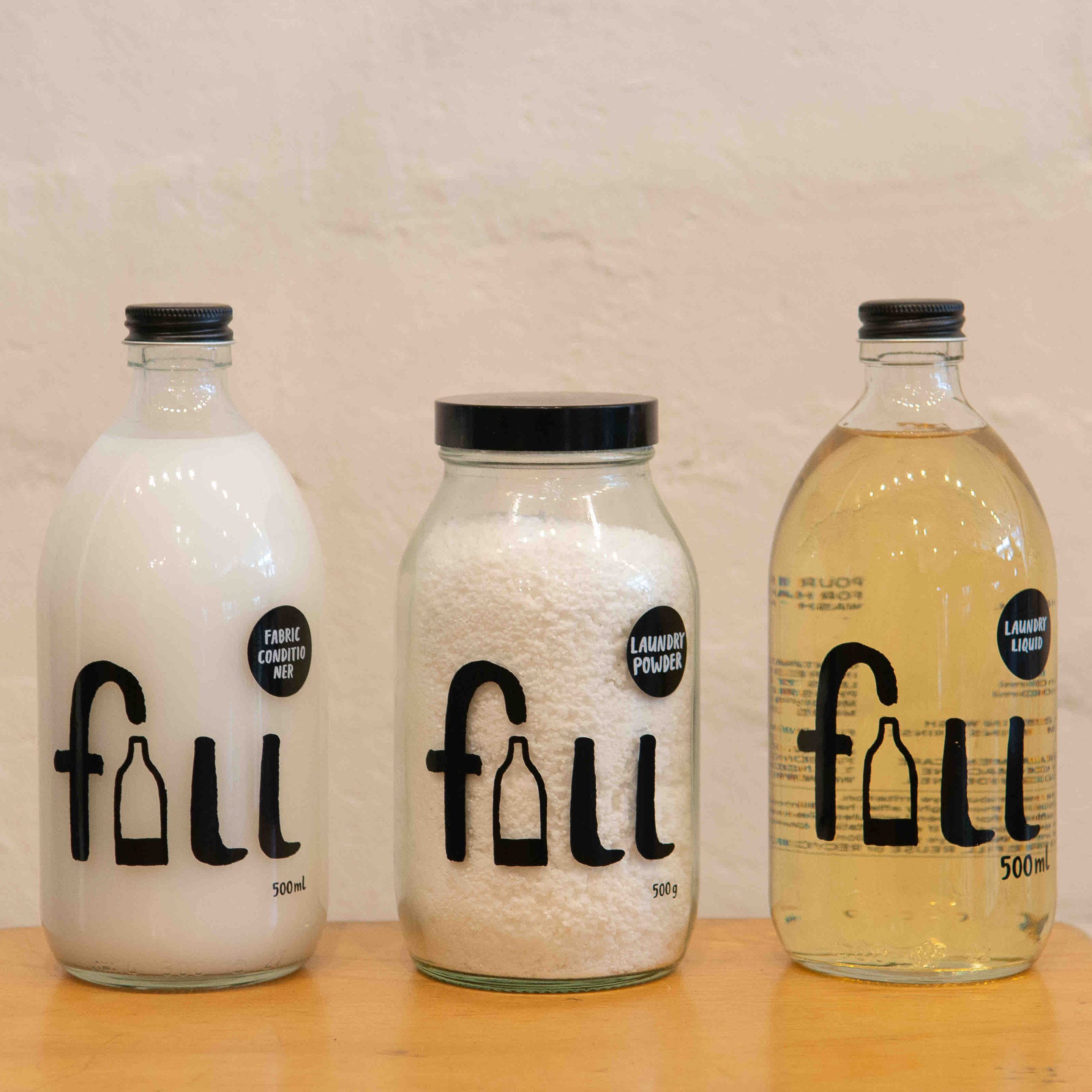 Three bottles of laundry products labeled as fabric conditioner, laundry powder, and laundry liquid, each with the brand "Fill."