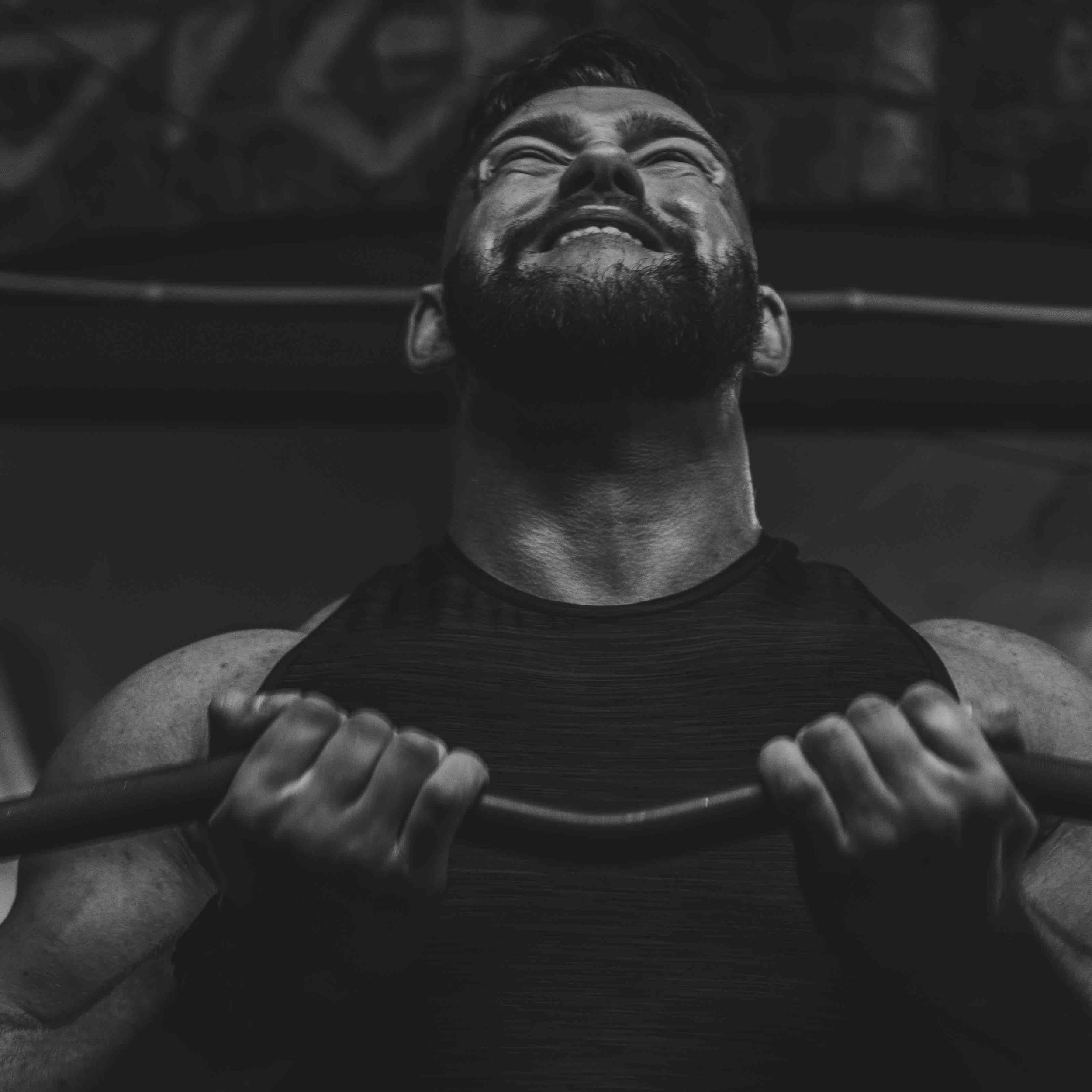 Man lifting weights with intense expression