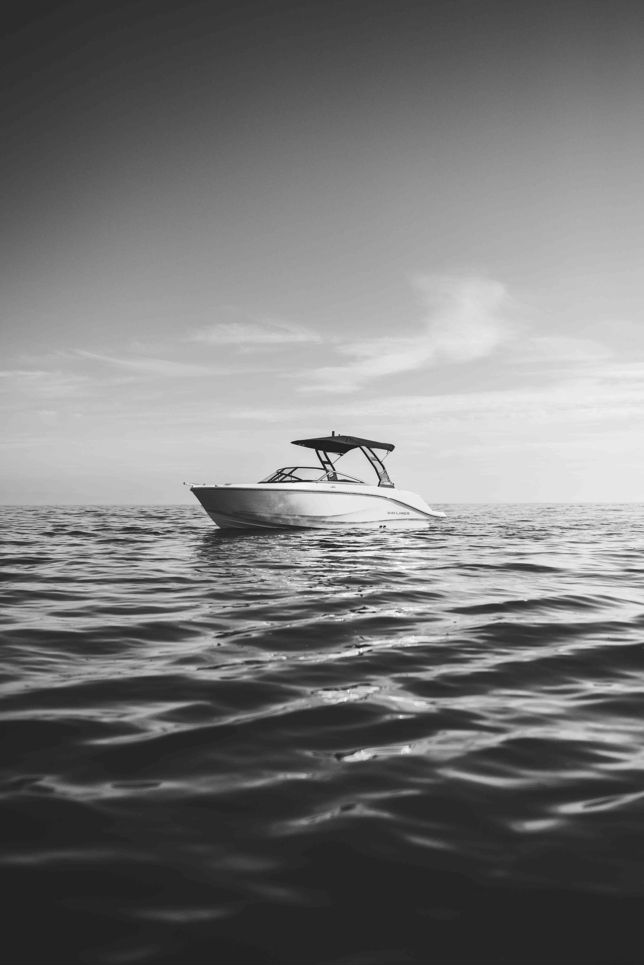 Black and white image of a boat on calm water