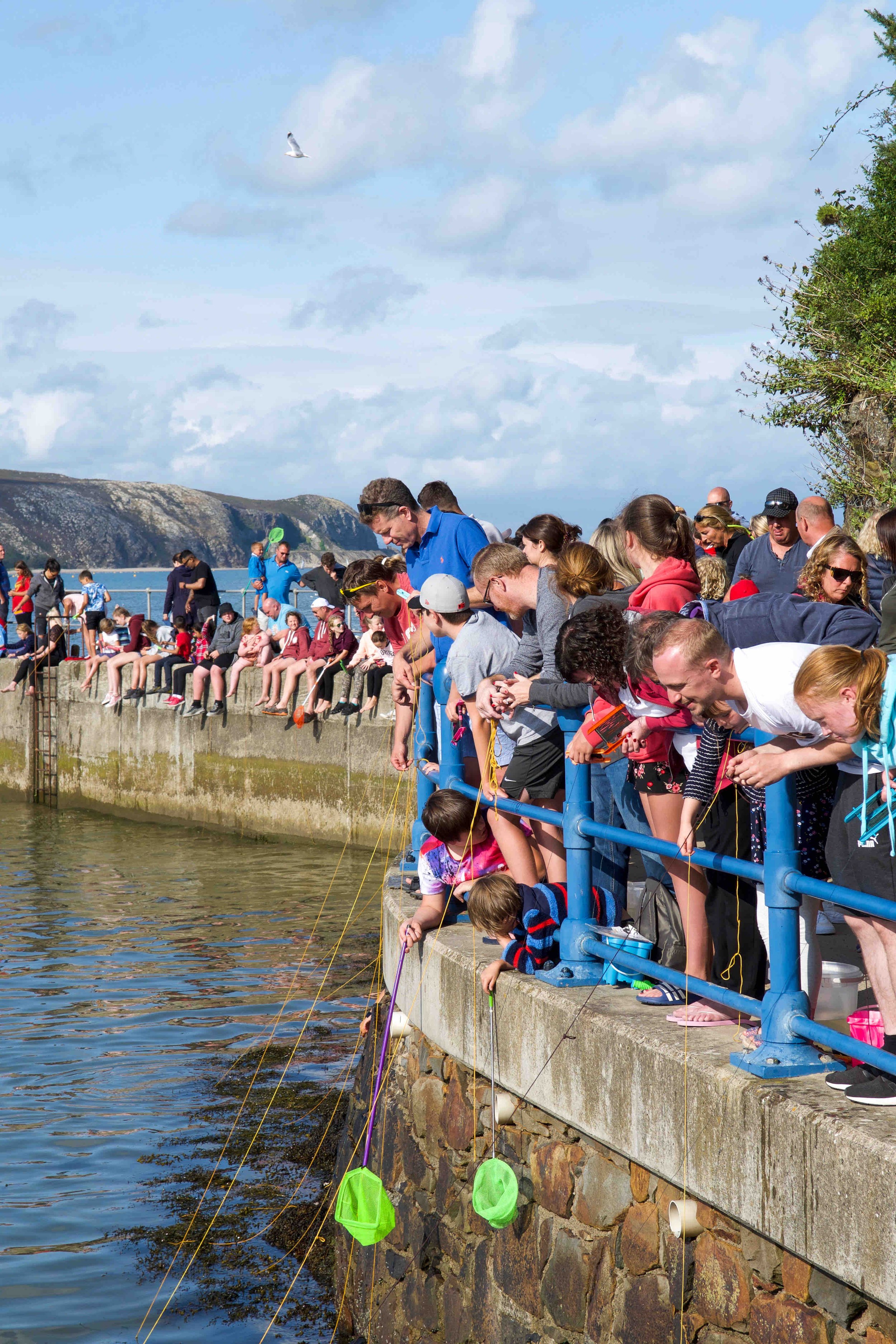 Crowd on seaside pier with fishing nets