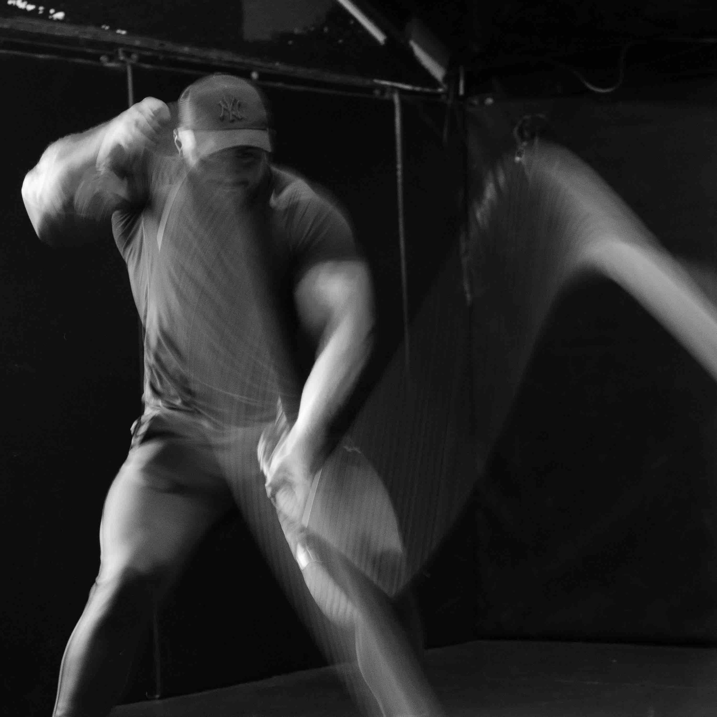 Man exercising with battle ropes in a gym.