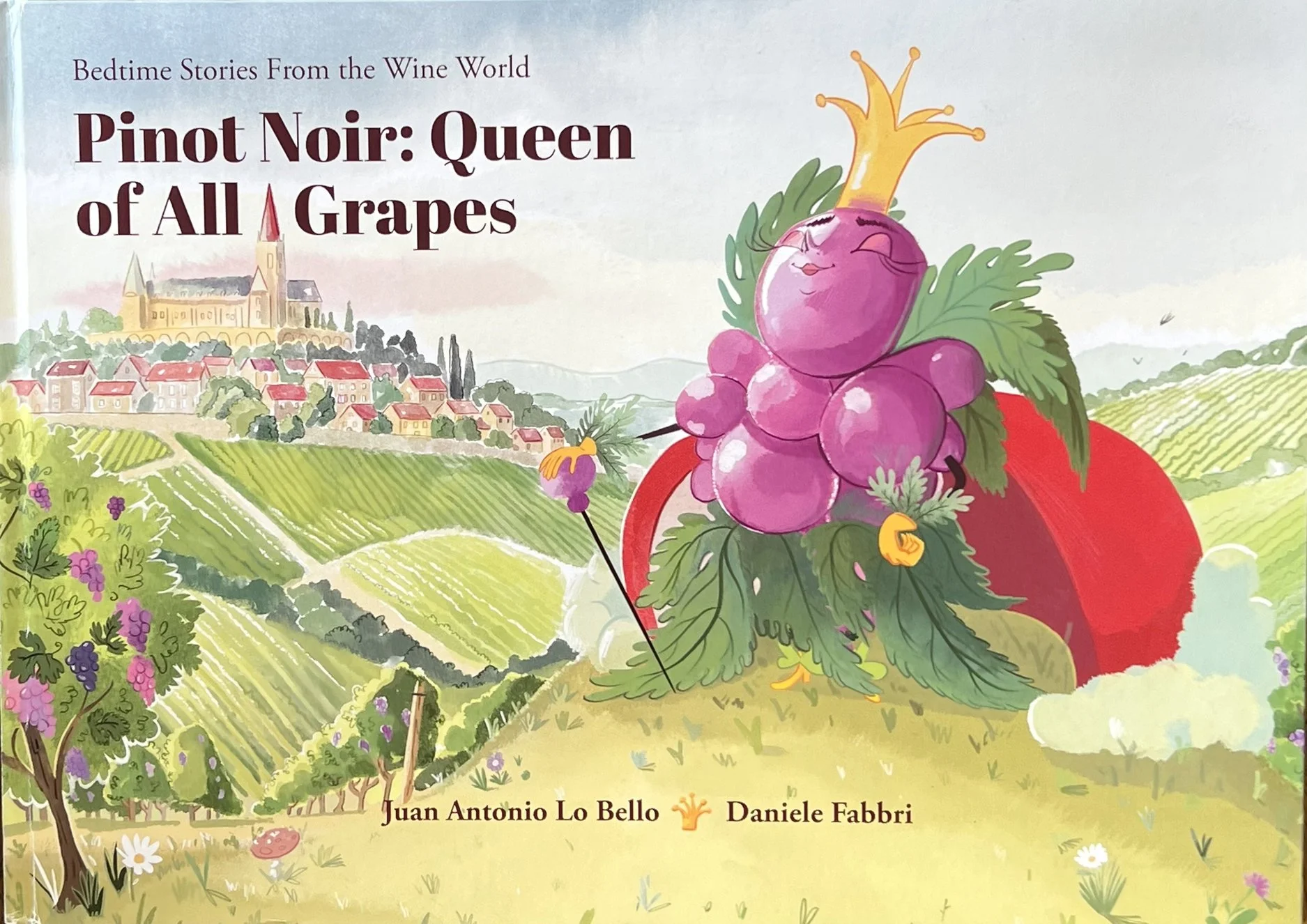 Book cover illustration of a vineyard scene with rolling hills, grapevines, and a castle on a hill in the background. A grape character with a crown and a smiling face is in the foreground.