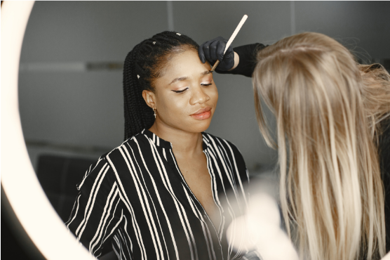 Makeup artist applying eyeshadow to woman's eyelid