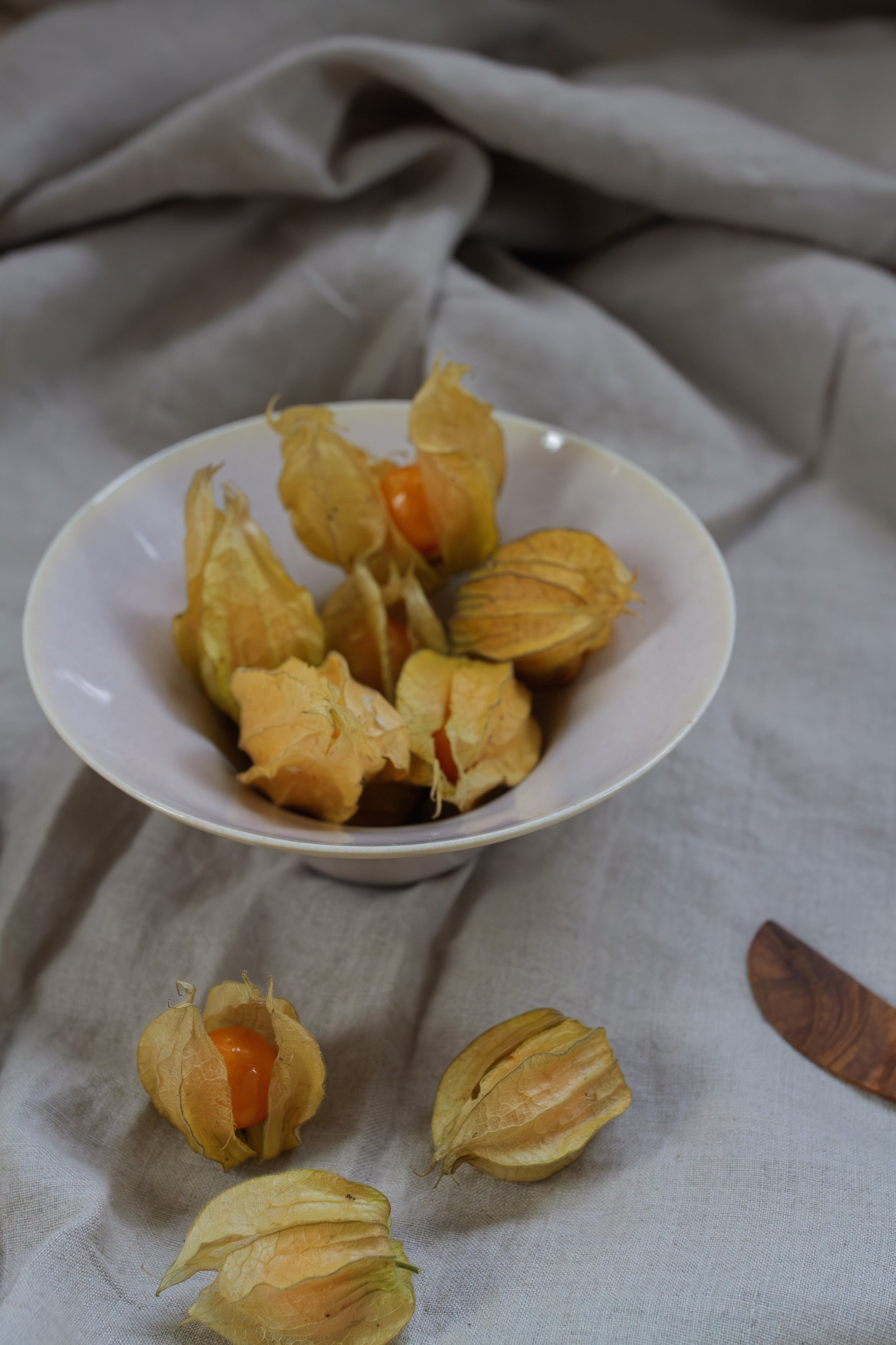 handmade porcelain Japanese wide rimmed bowl filled with cape gooseberries