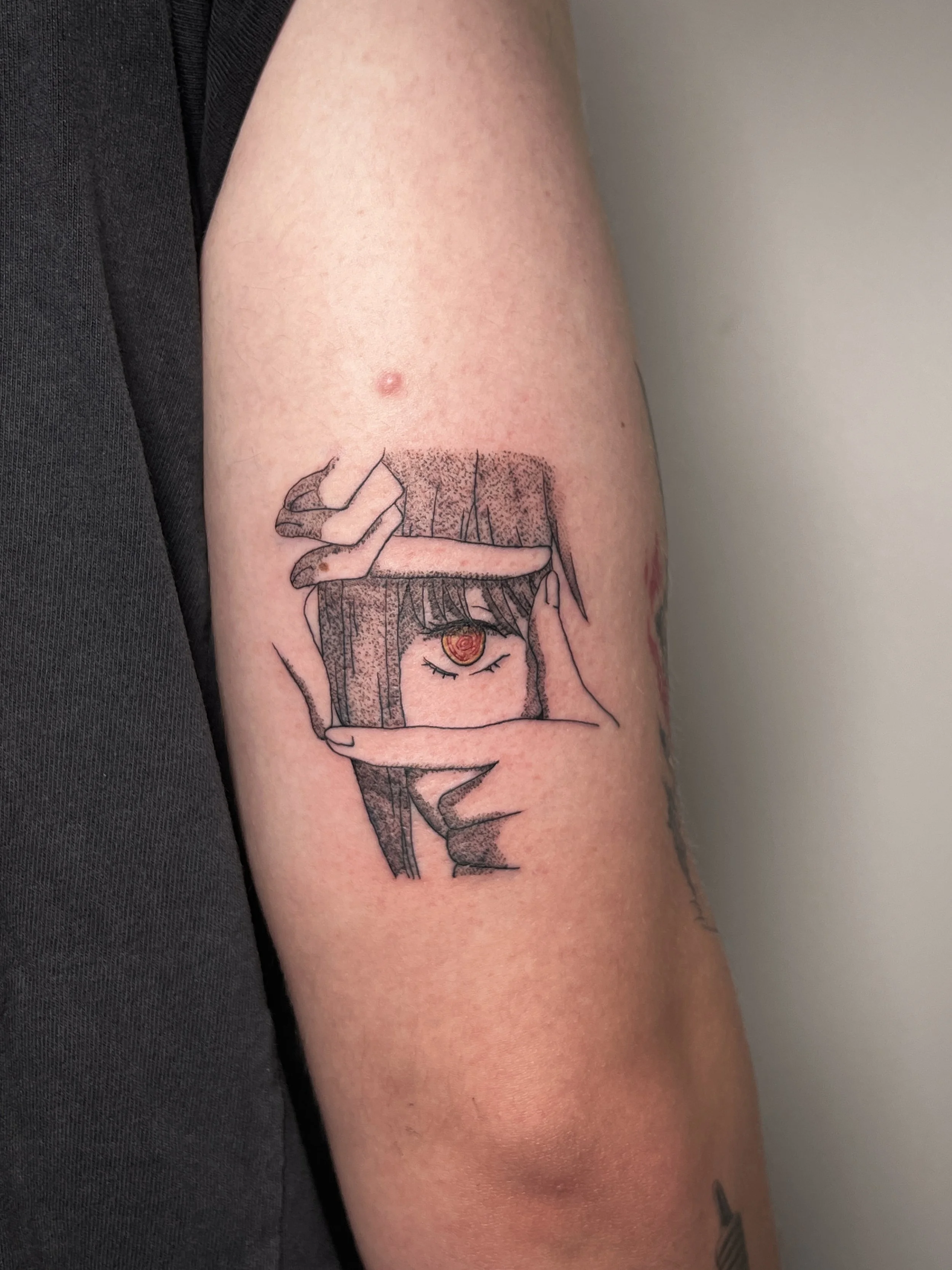 Tattoo on person's arm depicting a girl with long hair, forming a frame with her fingers around her eye. This character is Makima from the manga and anime Chainsaw Man