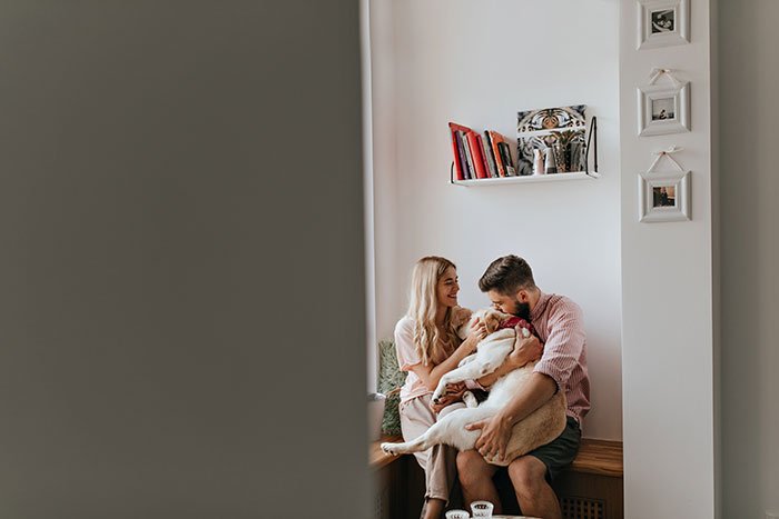 snapshot-through-open-door-couple-lovers-playing-with-their-big-white-dog-cozy-bright-room.jpg