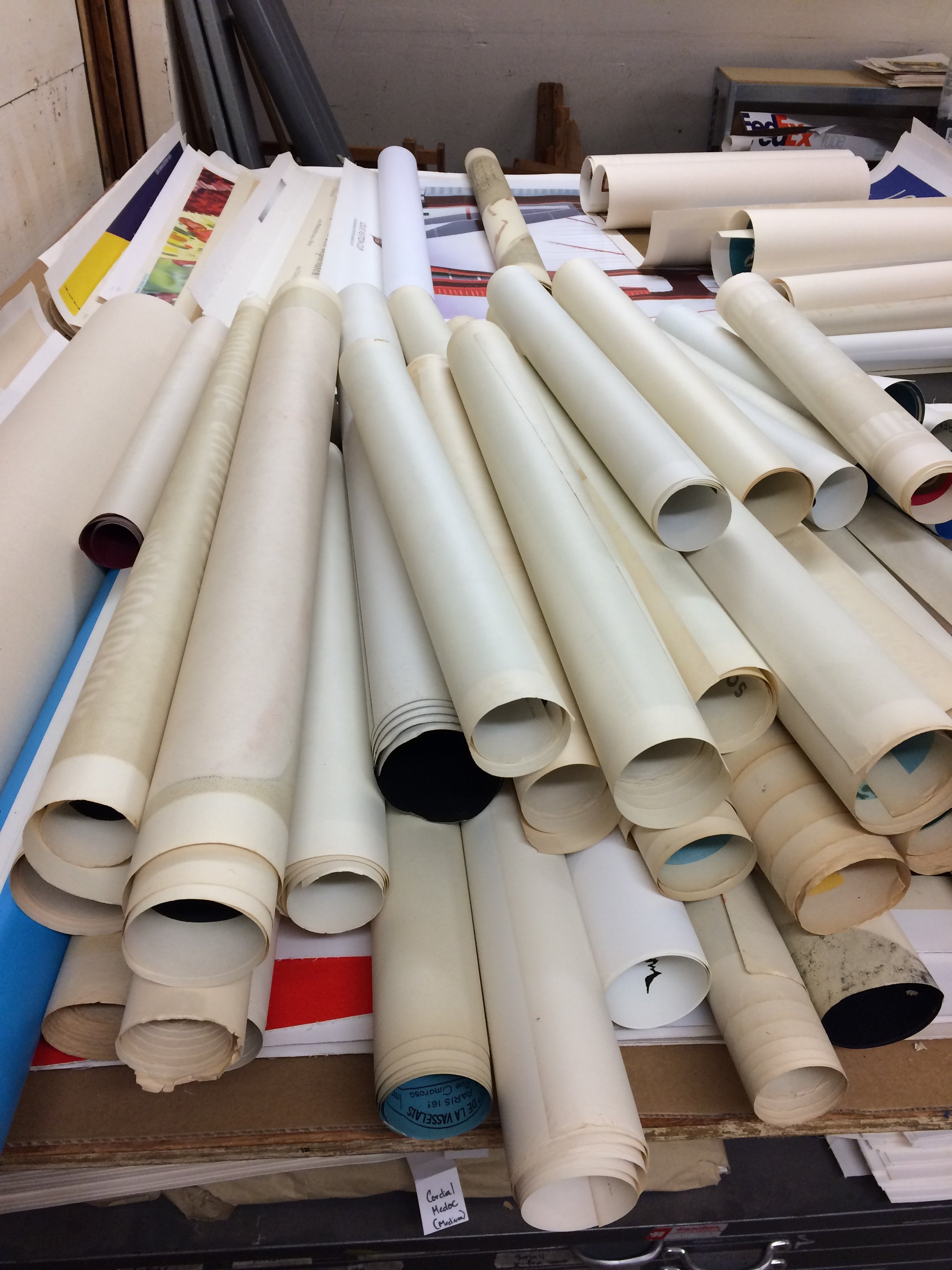 An assortment of rolled-up vintage posters ready to be preserved and catalogued for a private collector.