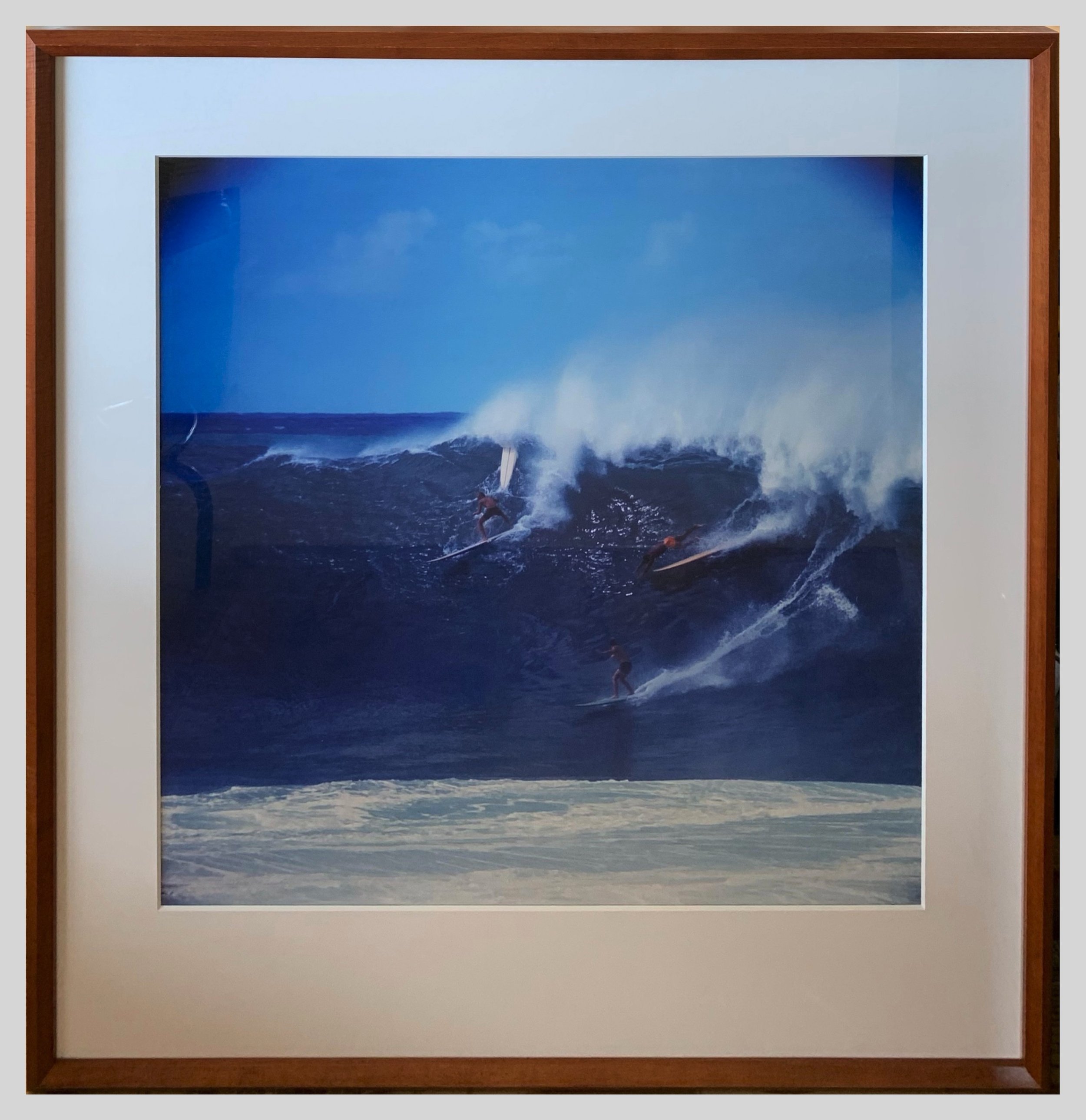 An original mid-twentieth century photograph featuring Hawaiian surfers on a big wave in a hand-crafted koa wood frame.