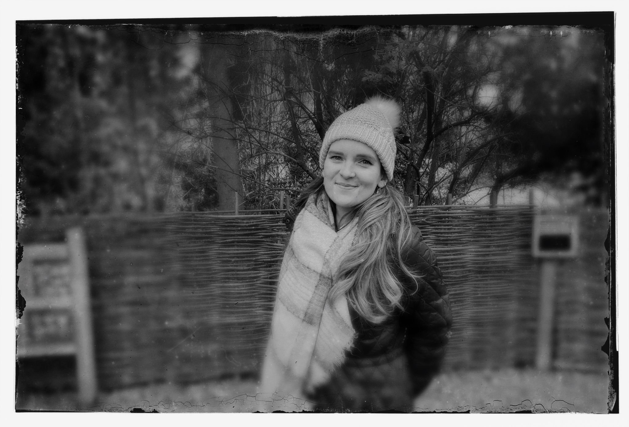 A black and white photograph of the editor, Laura Perry, smiling and dressed in winter clothes.
