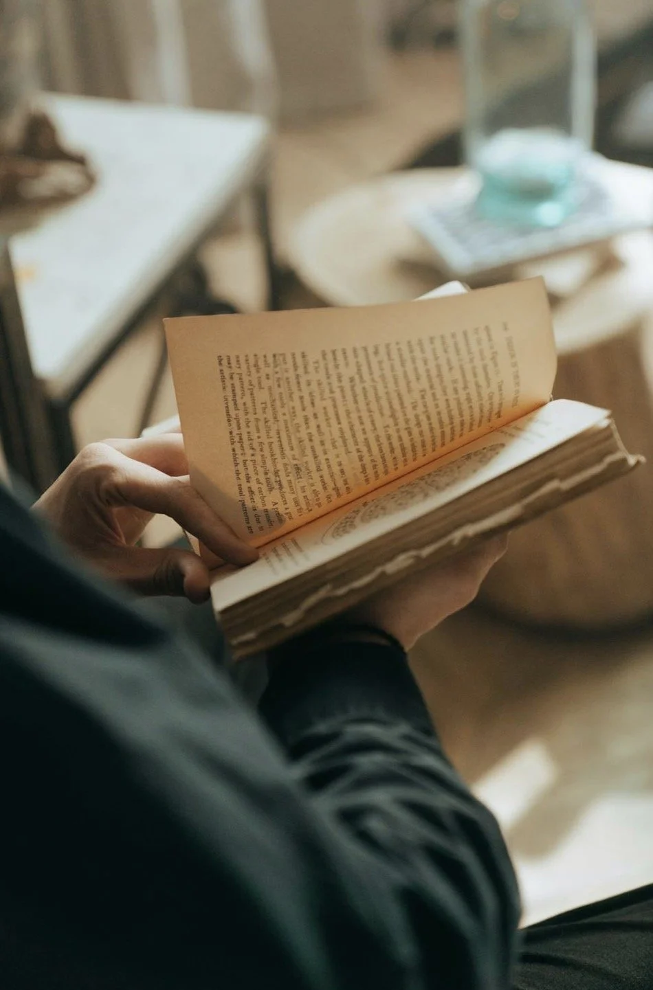 A person reading a careworn book while standing.