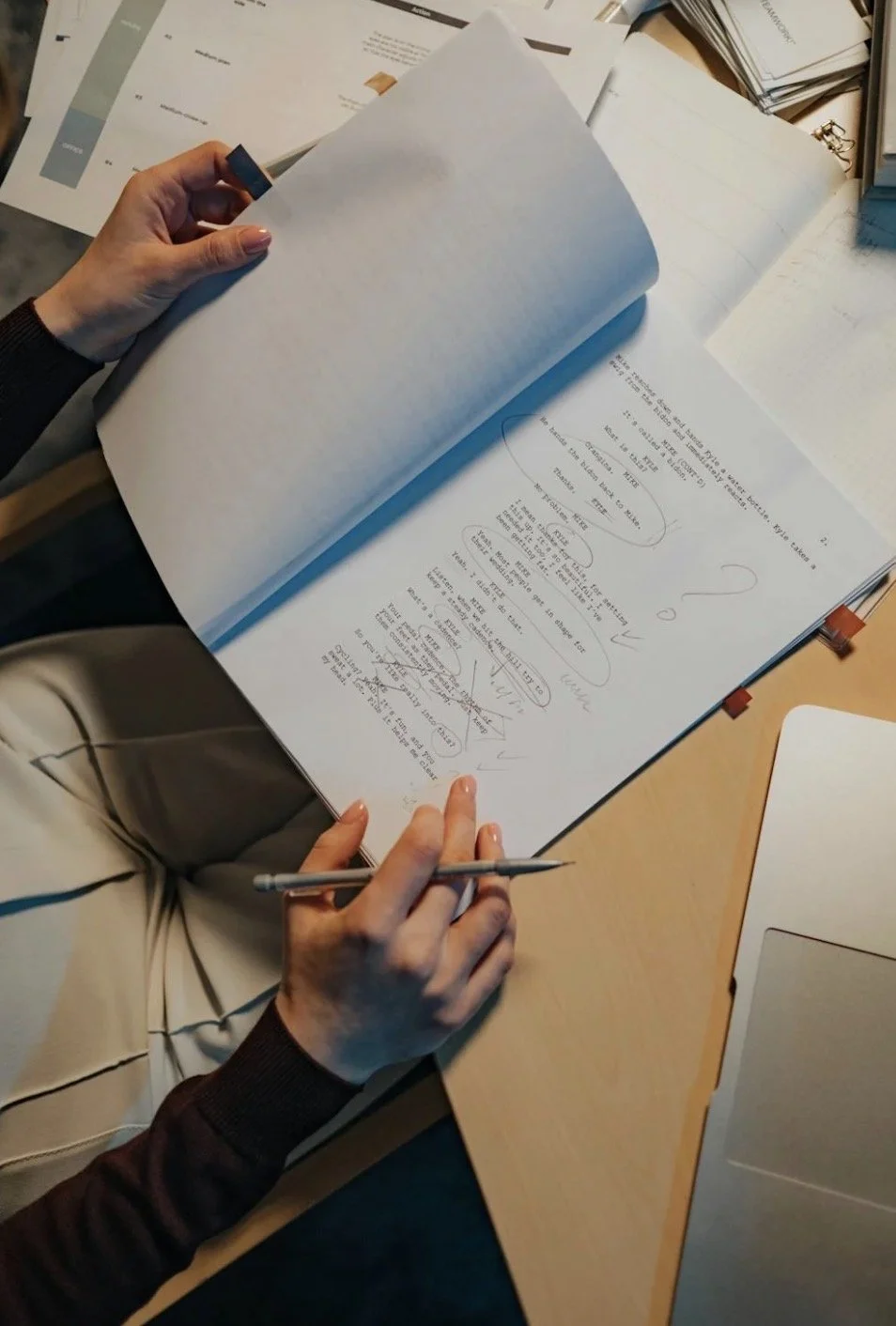 A bird's eye view of an editor working at her desk on a manuscript