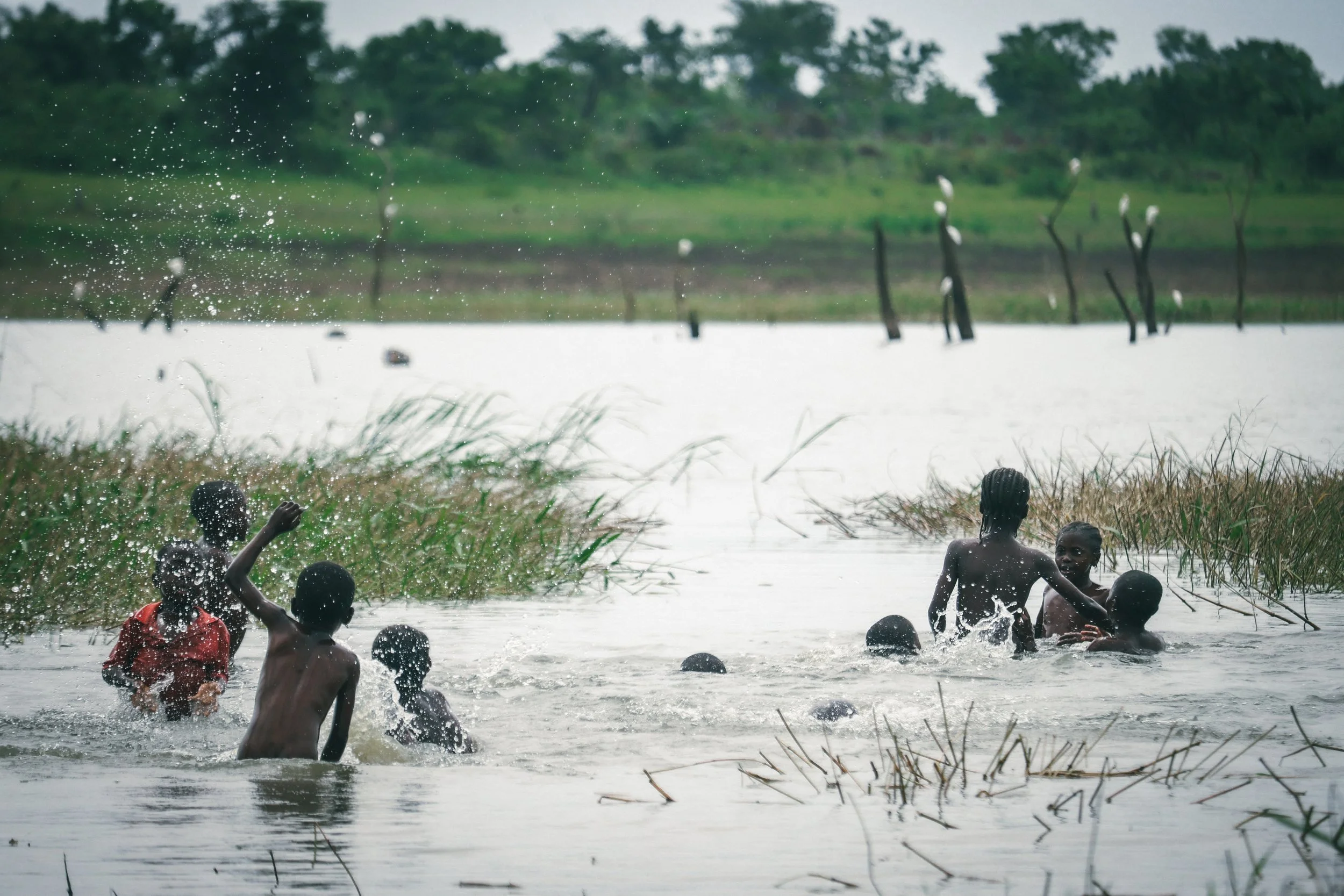 Children playing in the Oyan River in Apojola, where interaction with the water is a way of life - for play, work, laundry, and bathing