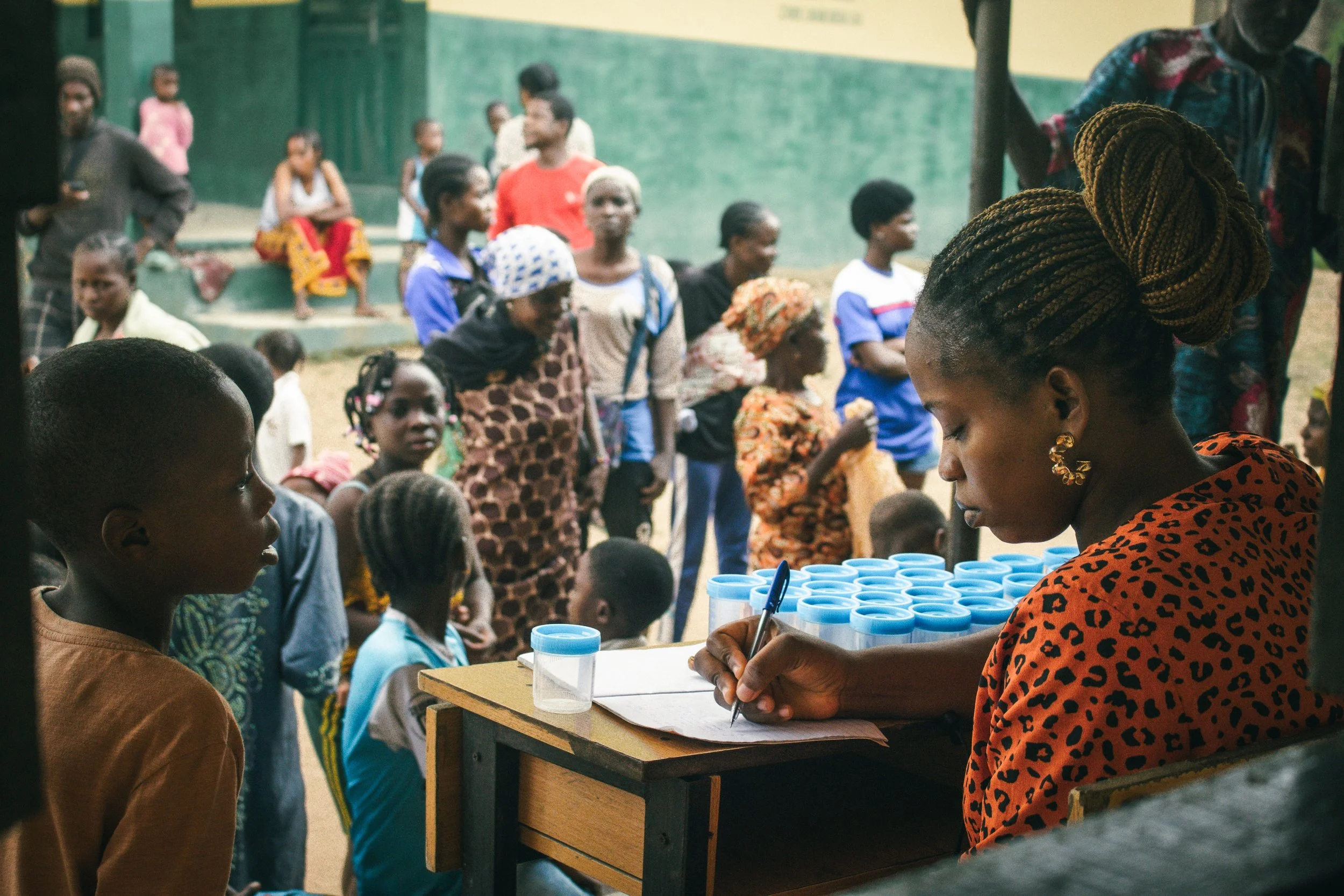 Community health worker Nifemi conducting patient intake prior to schistosomiasis testing and consequent praziquantel administration