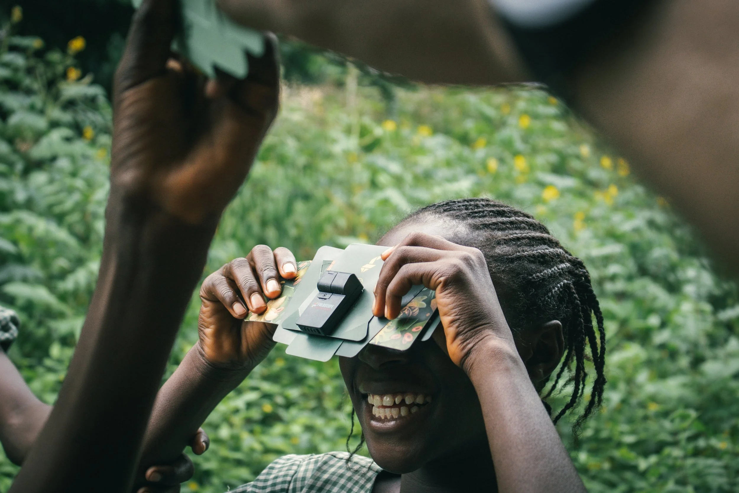 A student in Apojola views plant leaves microscopically for the first time after learning to assemble and use a Foldscope