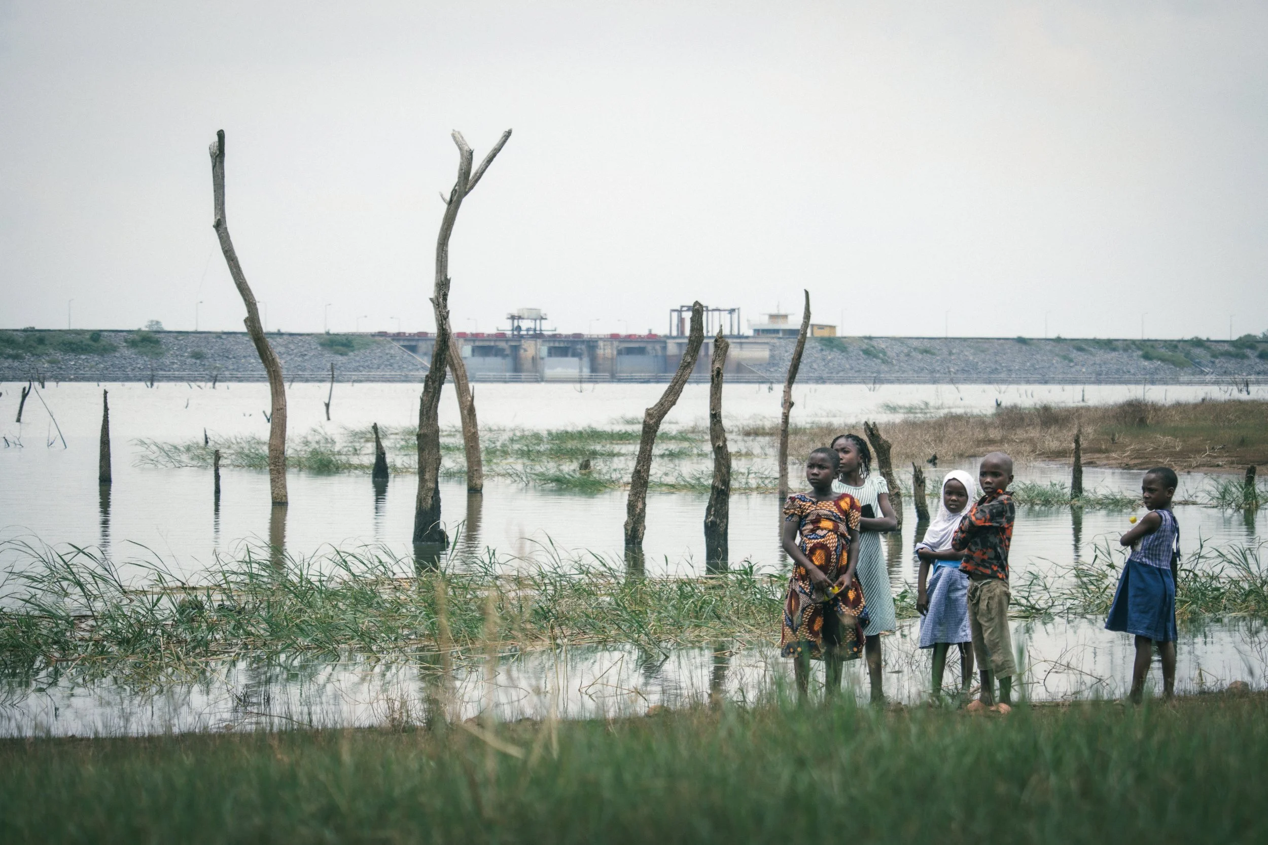 Children of Abule Titun in front of the Oyan Dam; constructed in 1983, the dam is largely responsible for the surge of schistosomiasis in the Oyan River in recent decades due to the prevention of migration of prawns that predate  the host snails for 