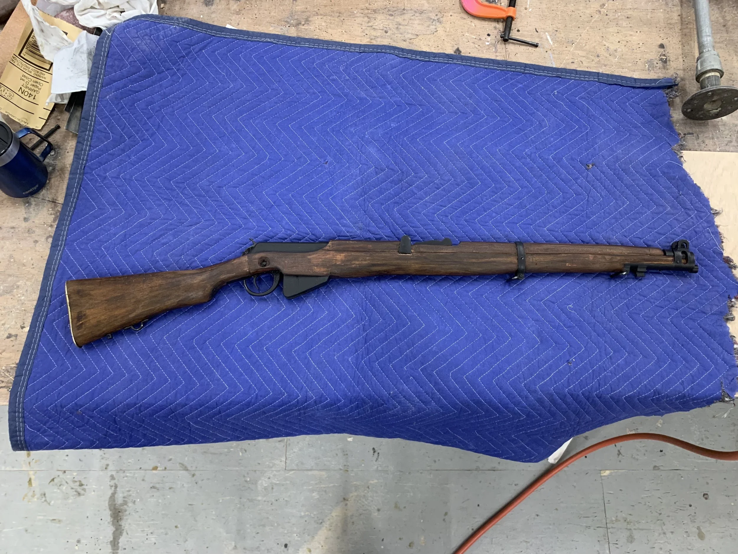 A blank firing lever action rifle modified to look like a Lee-Enfield rifle (The Santa Fe Opera). Made after examples produced by artisan Ariel Lacey. 