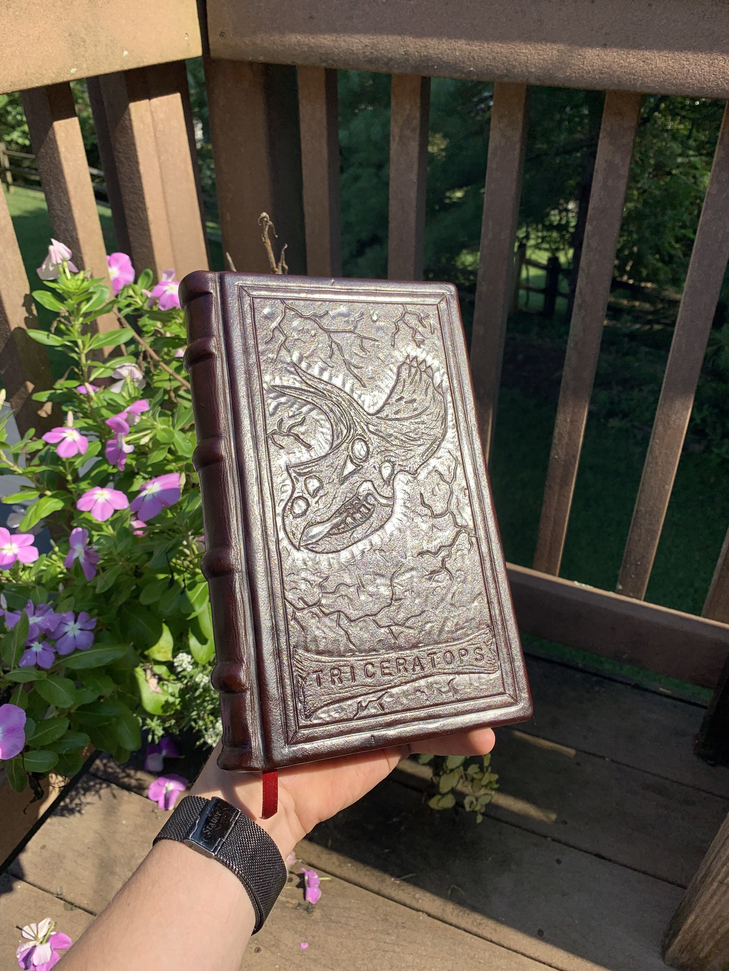 A triceratops themed hand bound book made of paper and veg tanned leather.