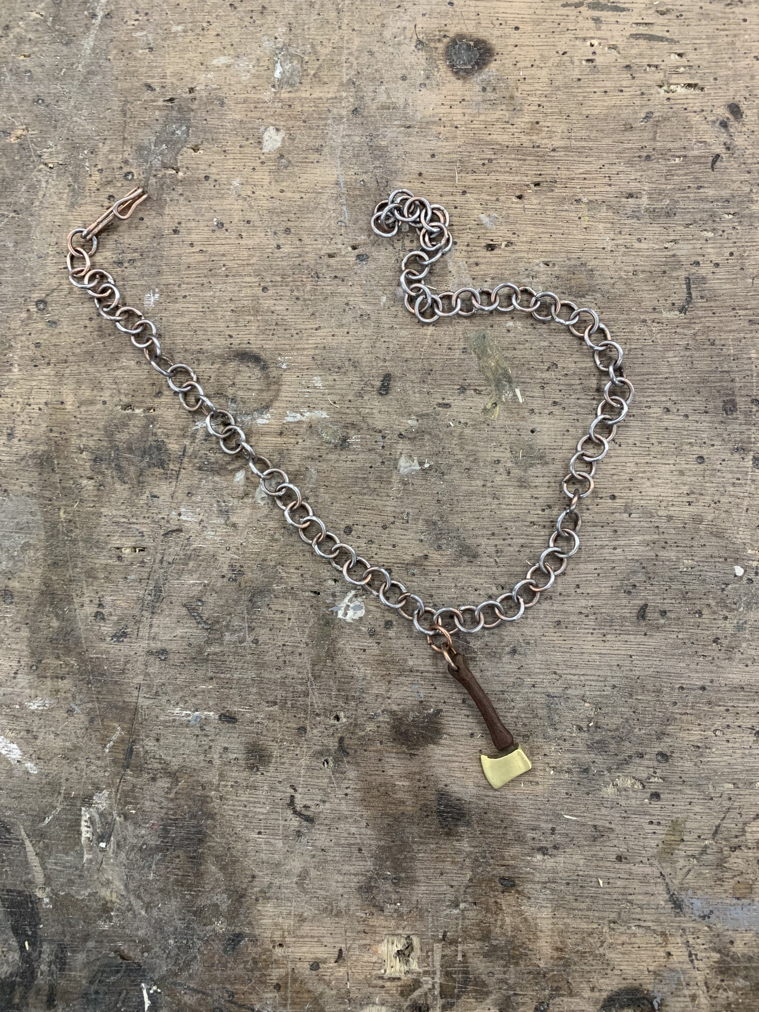 A necklace made of TIG welding rod, walnut, and brass as a means of practicing soldering.