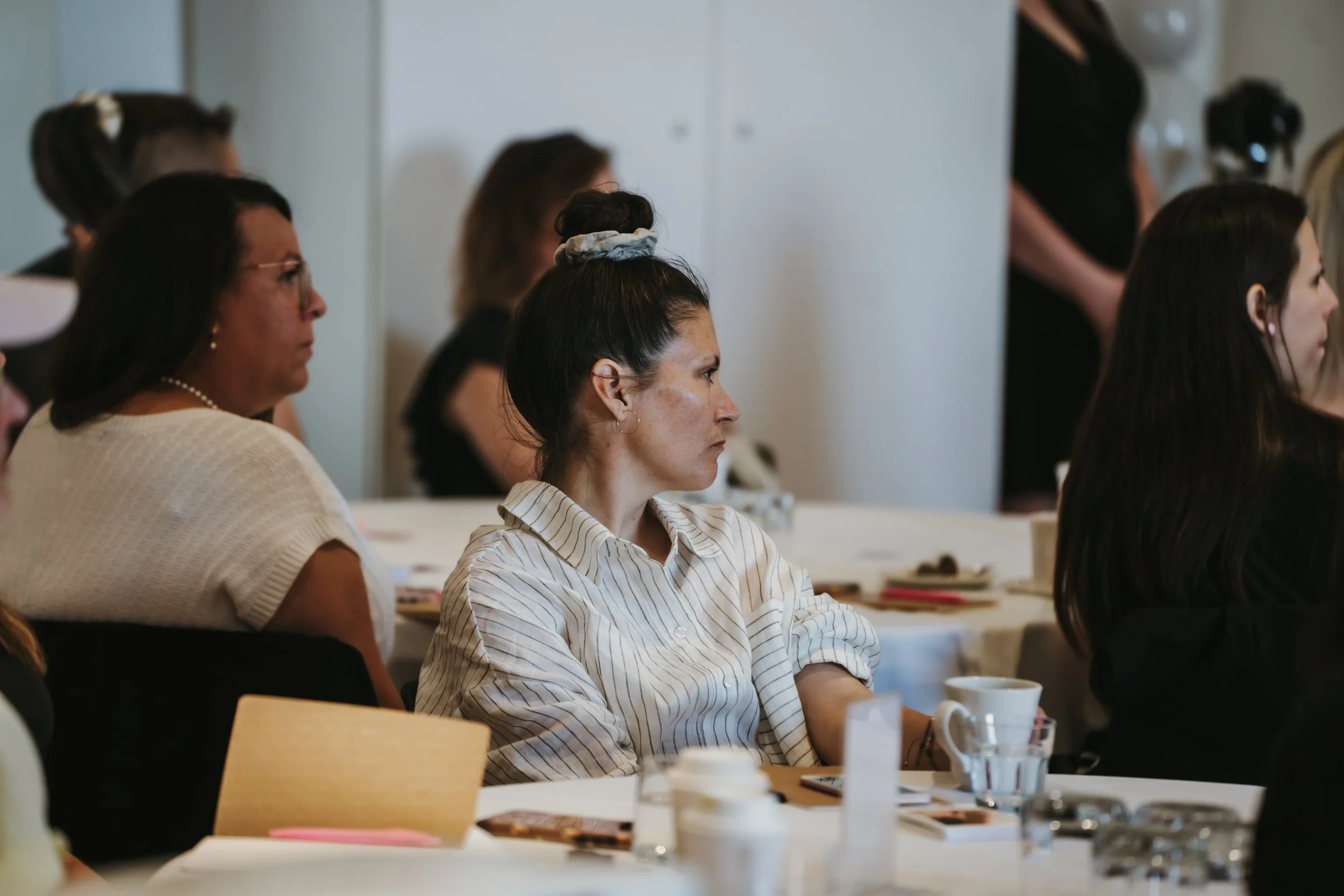 People sitting attentively in a meeting or conference setting.