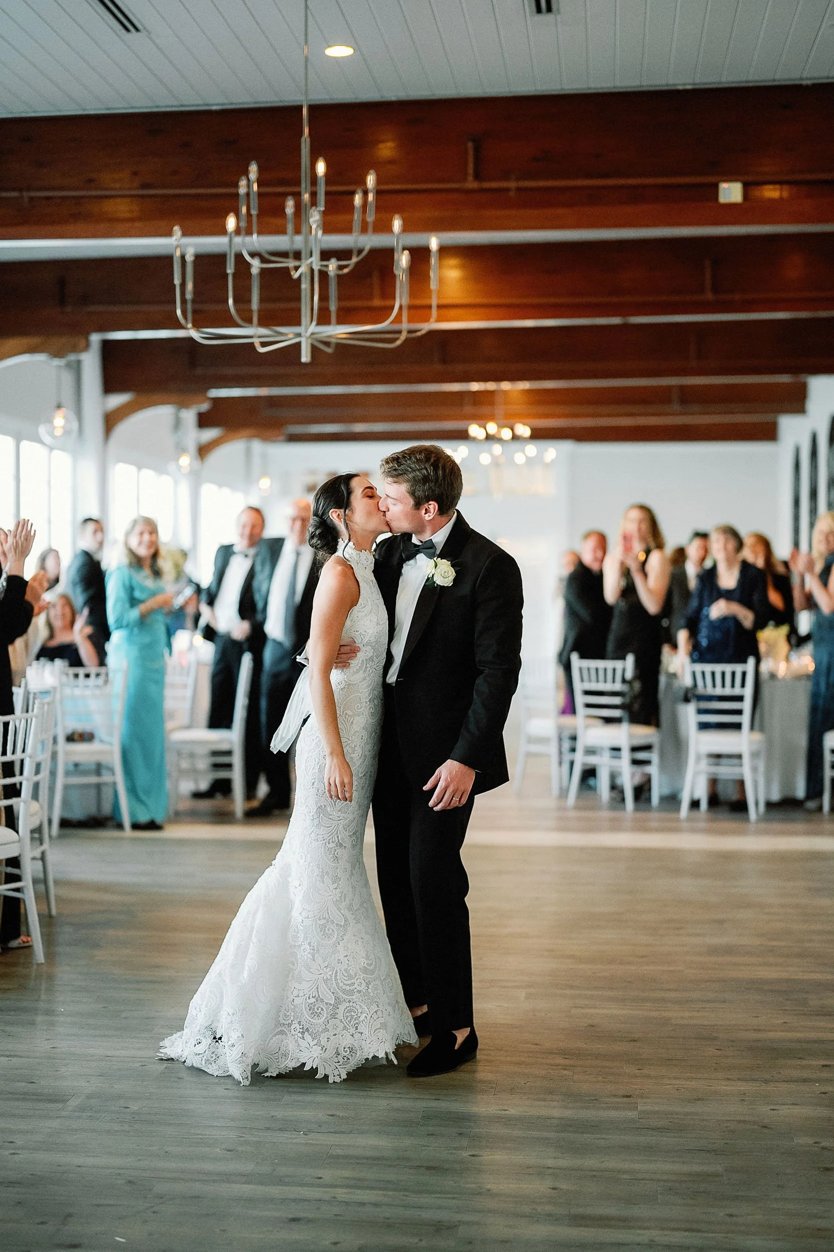 A bride and groom kissing during their wedding reception.