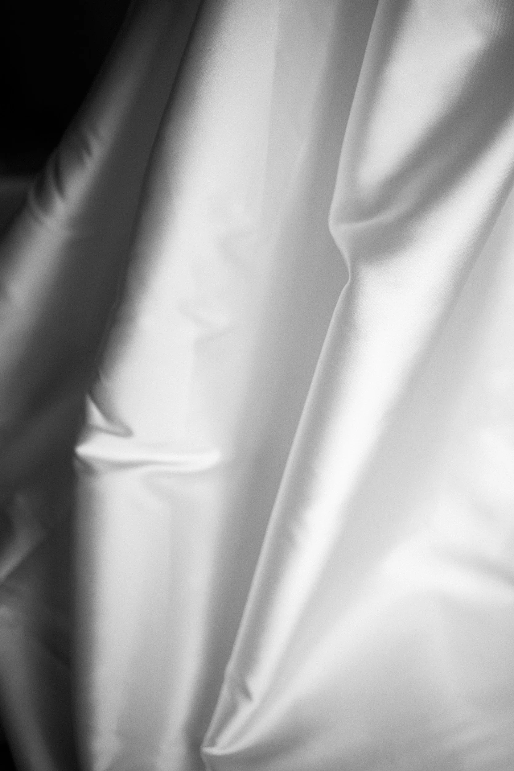 Close-up view of smooth, shiny satin fabric draped and folded.