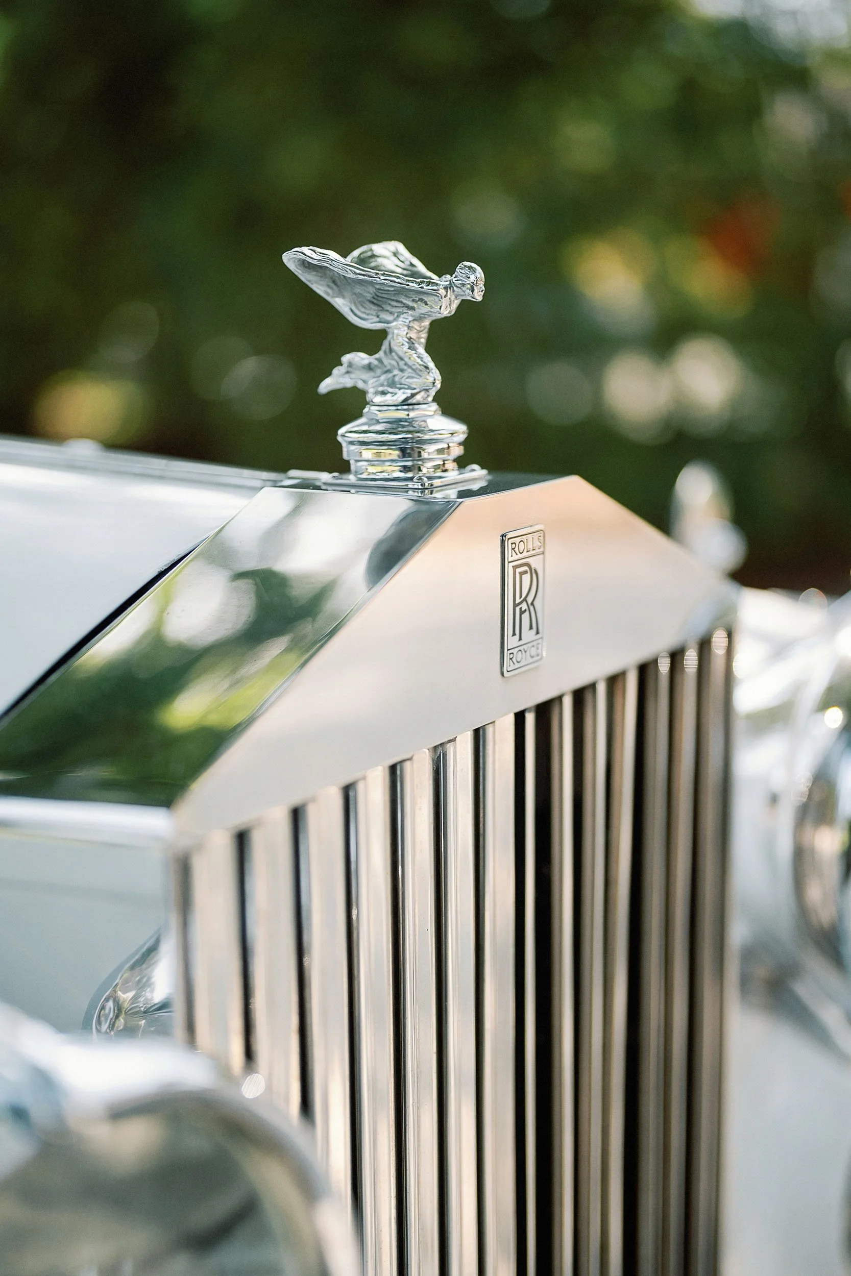 Close-up of a vintage Rolls-Royce car hood ornament and grille.