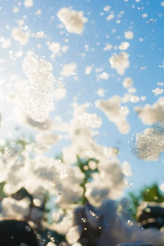 Bright sunny day with foam floating in the air during a South Bay outdoor event