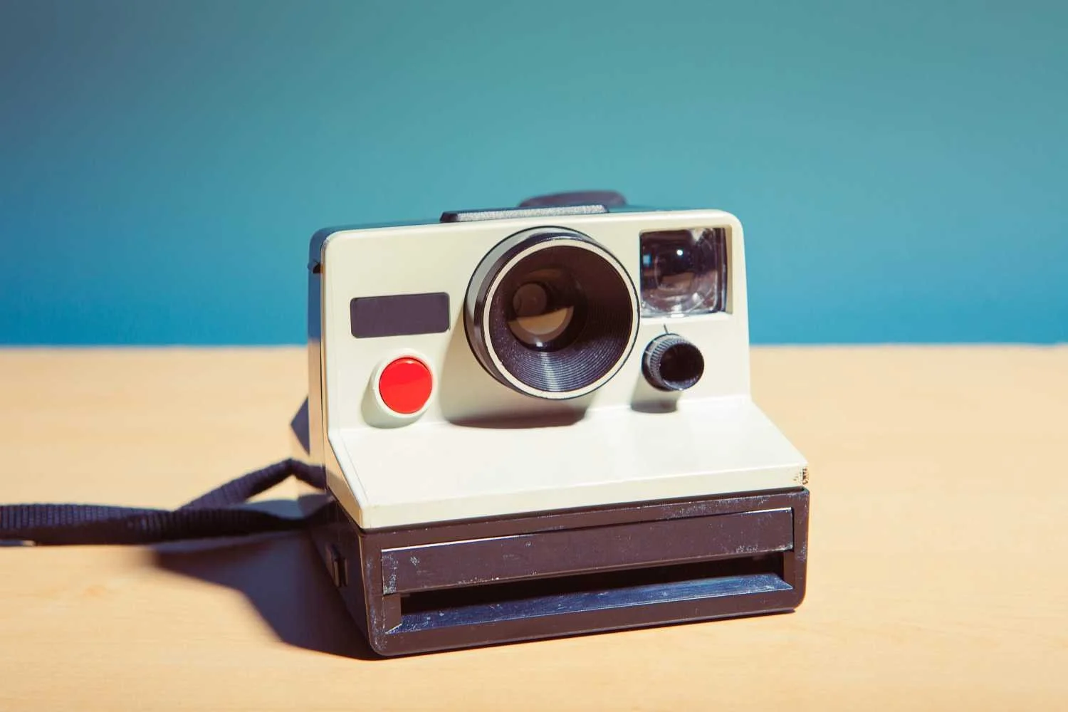 A retro Polaroid camera on a blue and cream background, symbolizing the fun, classic memories created by our party activity options.