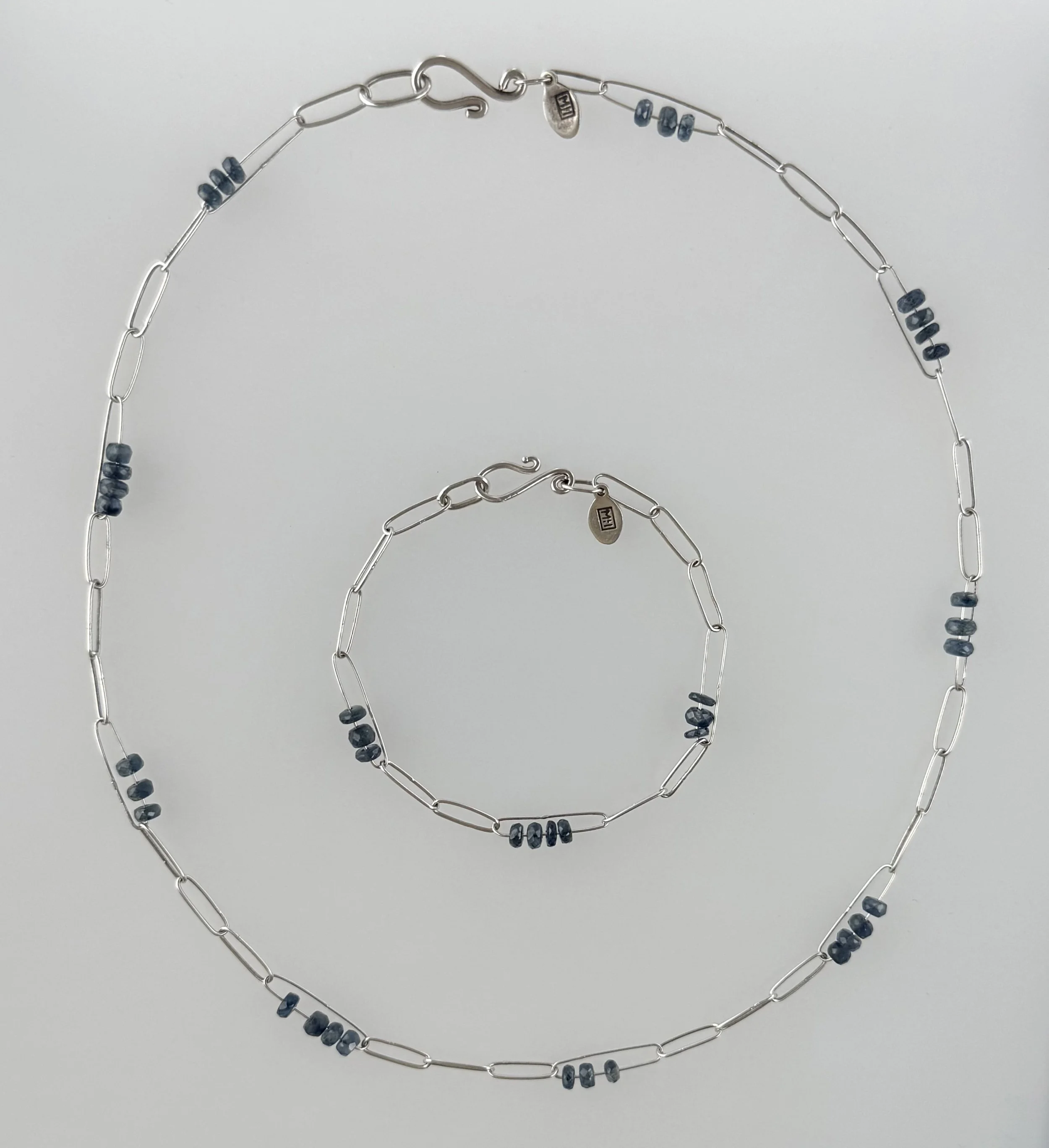 A matching set of jewelry necklace and bracelet with silver links and small dark blue (3mm Kyanite faceted round) beads.