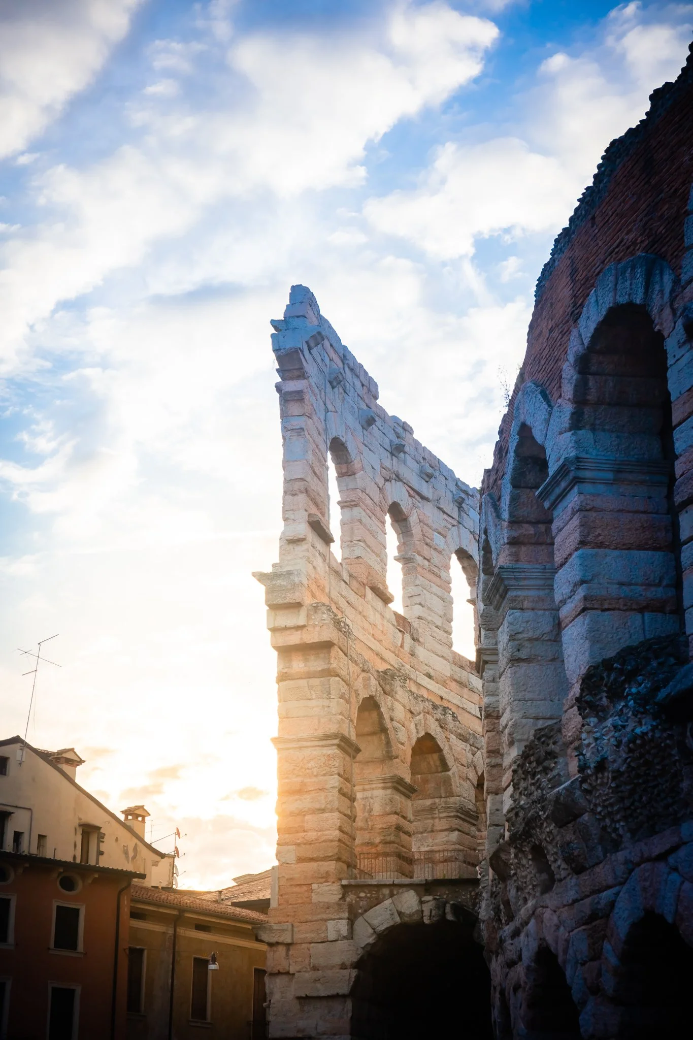 Ancient Roman amphitheater ruins against a cloudy sky