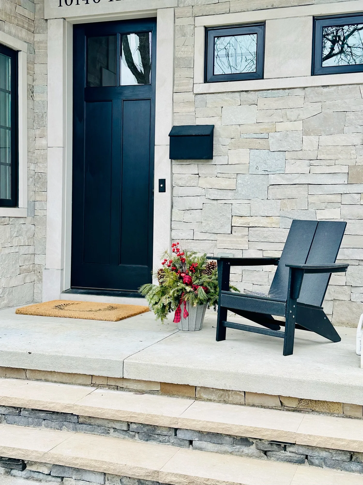 Dark entry door installed at a stone-front home