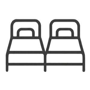 Two beds with yellow blankets and blue pillows in a bedroom