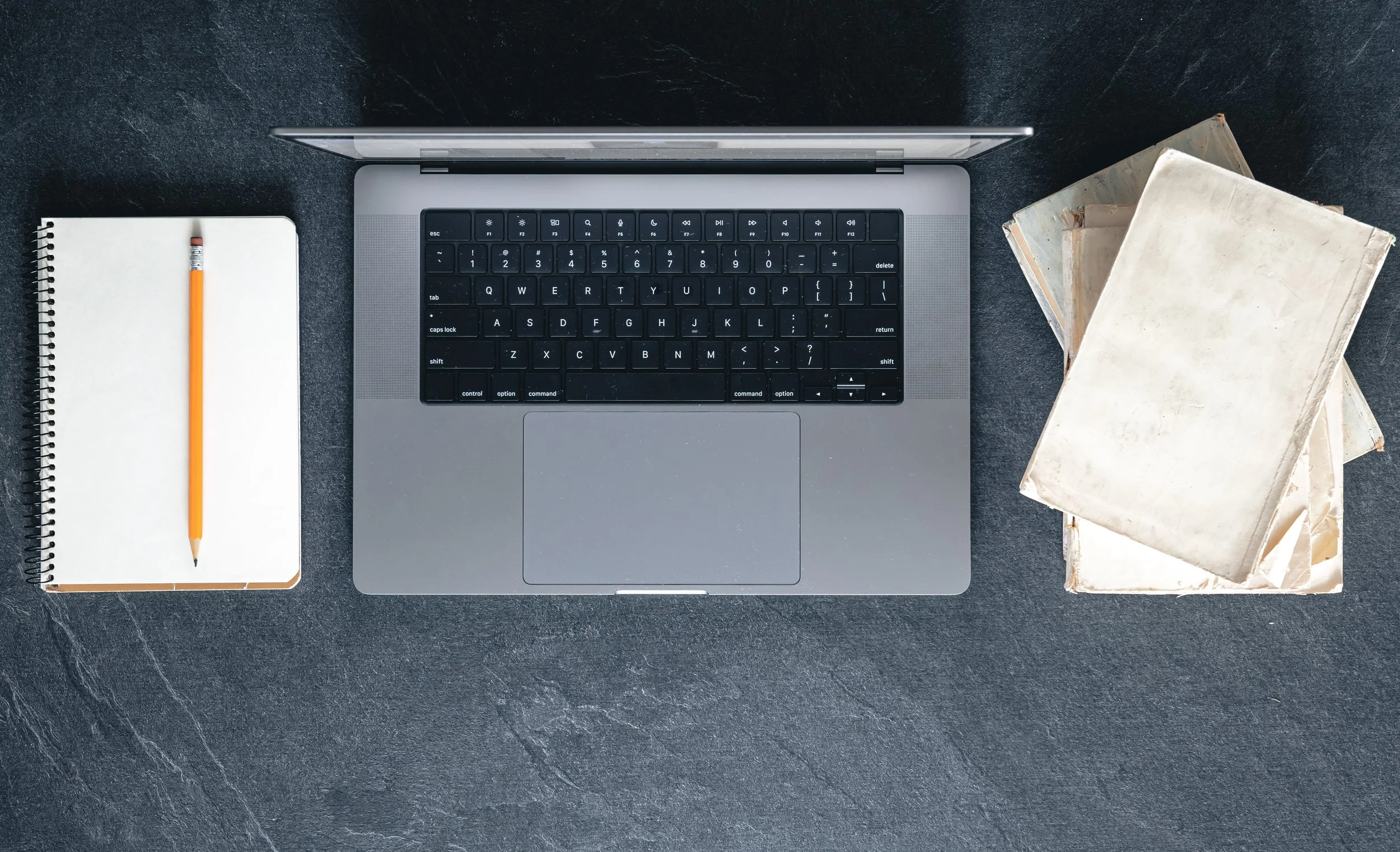 <a href="https://www.freepik.com/free-photo/laptop-books-notepad-dark-textured-background-top-view_136763832.htm">Image by pvproductions on Freepik</a>