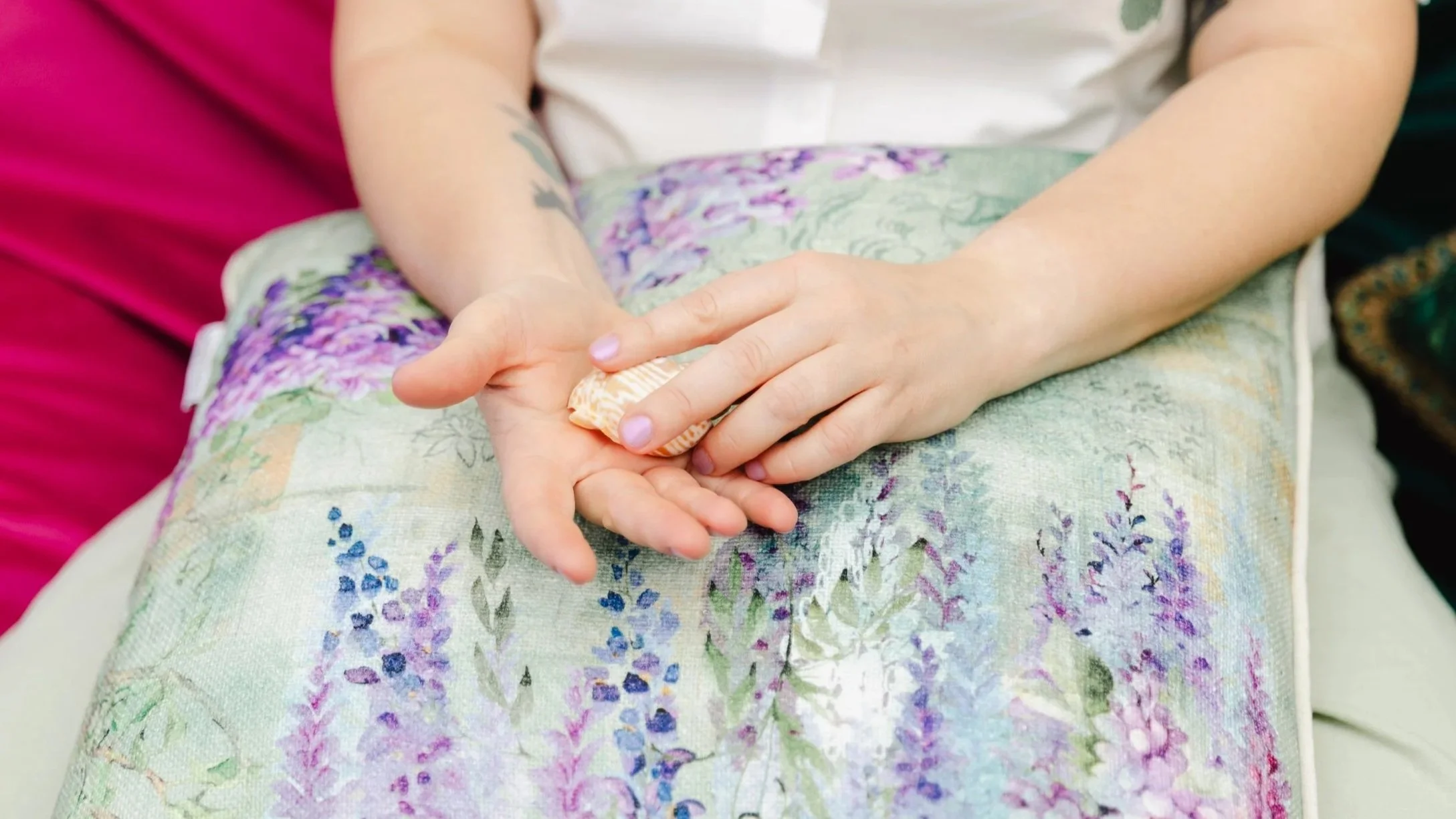 Close-up of a participant’s hands resting in their lap holding an object during a wheel of consent workshop.