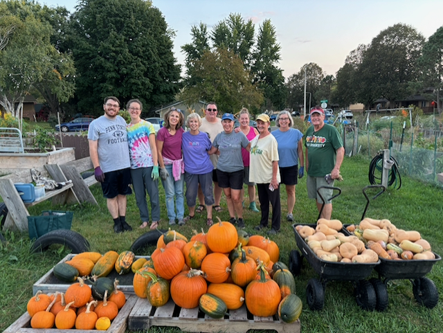 Garden volunteers show pumpikins and gourads harvested in fall 2025