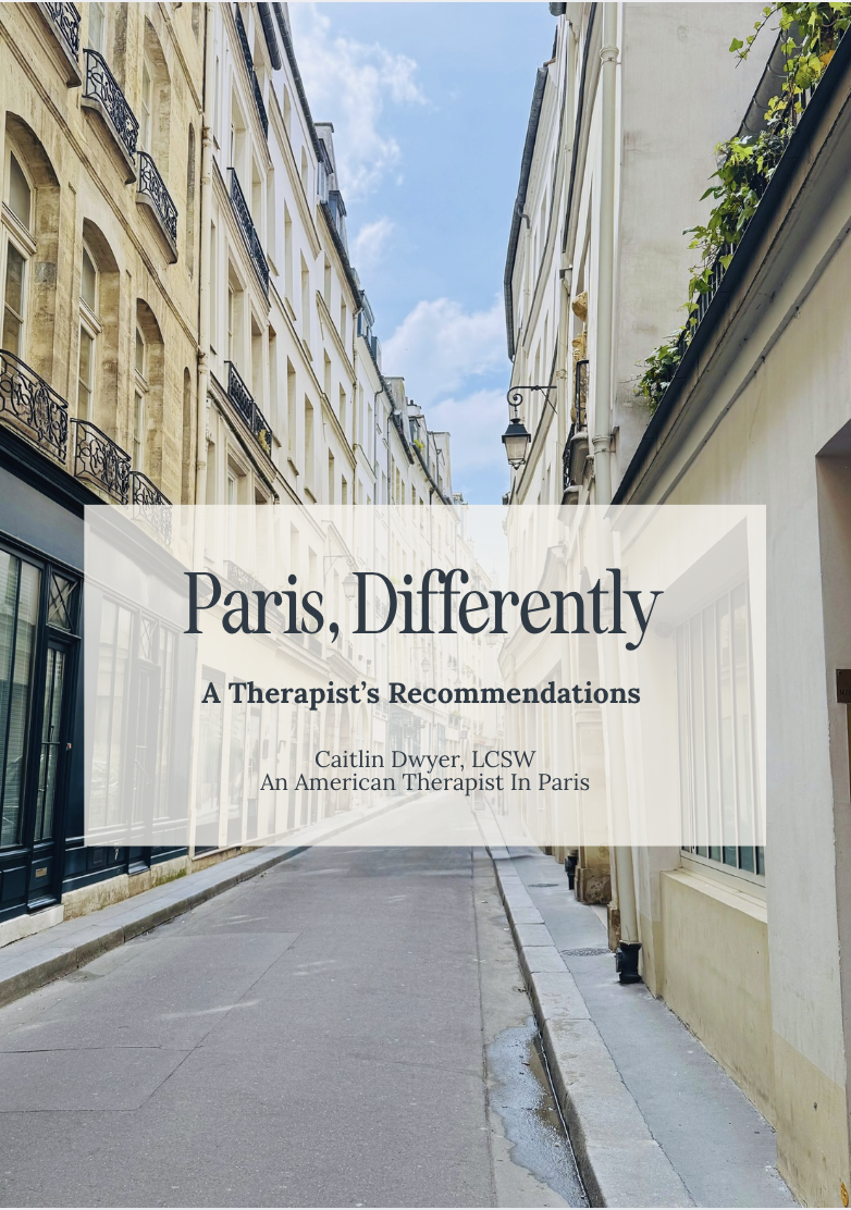 A narrow Paris street with classic European buildings, balconies, and a blue sky with clouds.