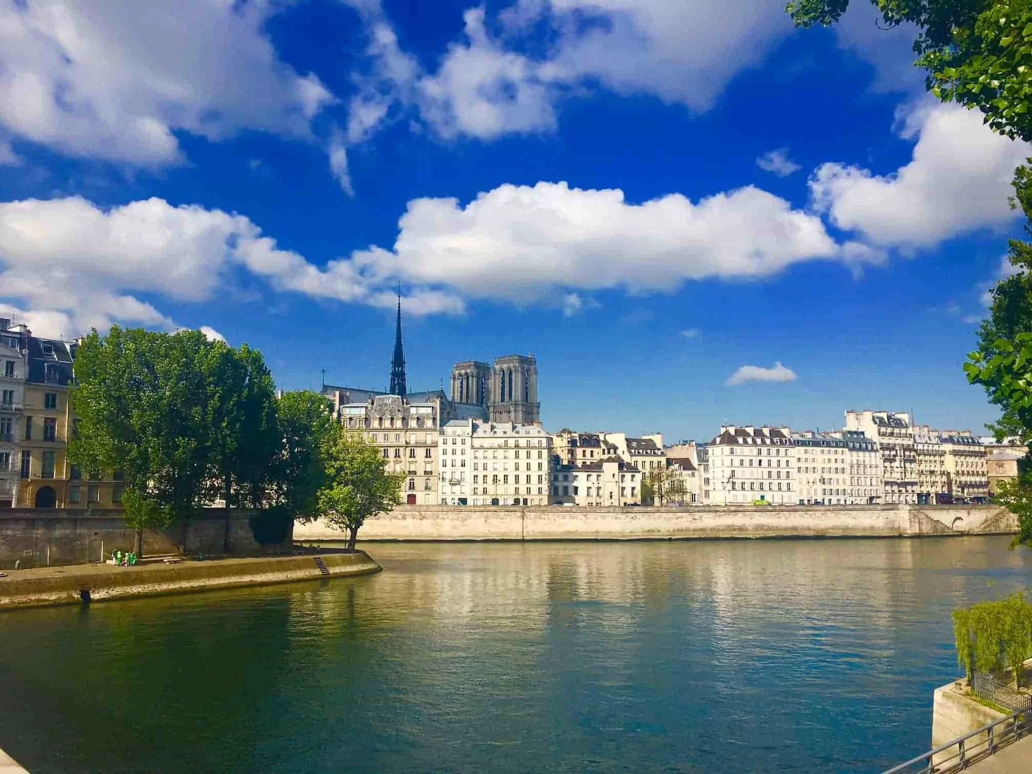 Overlooking river to notre dame with blue sky and green trees