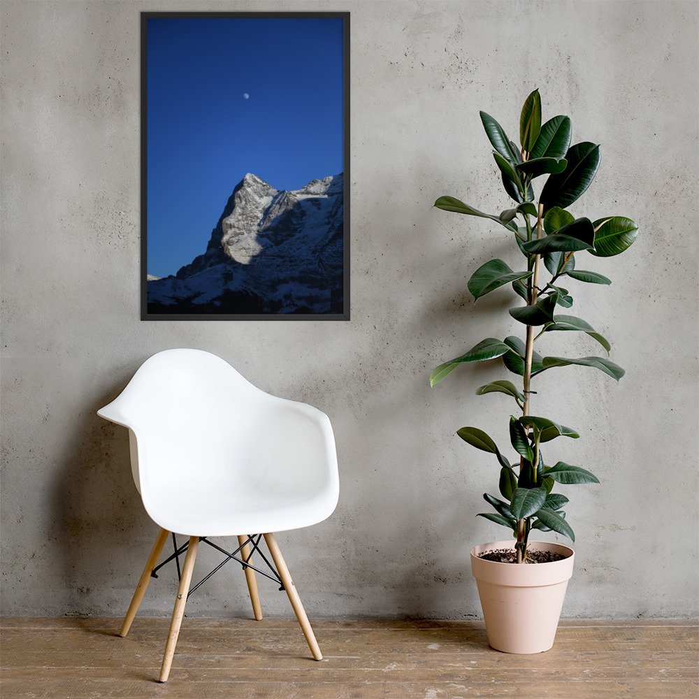 Mond über dem Grat im schwarzen Rahmen an einer Wand über einem weissen Stuhl neben einer Pflanze. Raumvisualisierung / framed photograph in a room mockup.